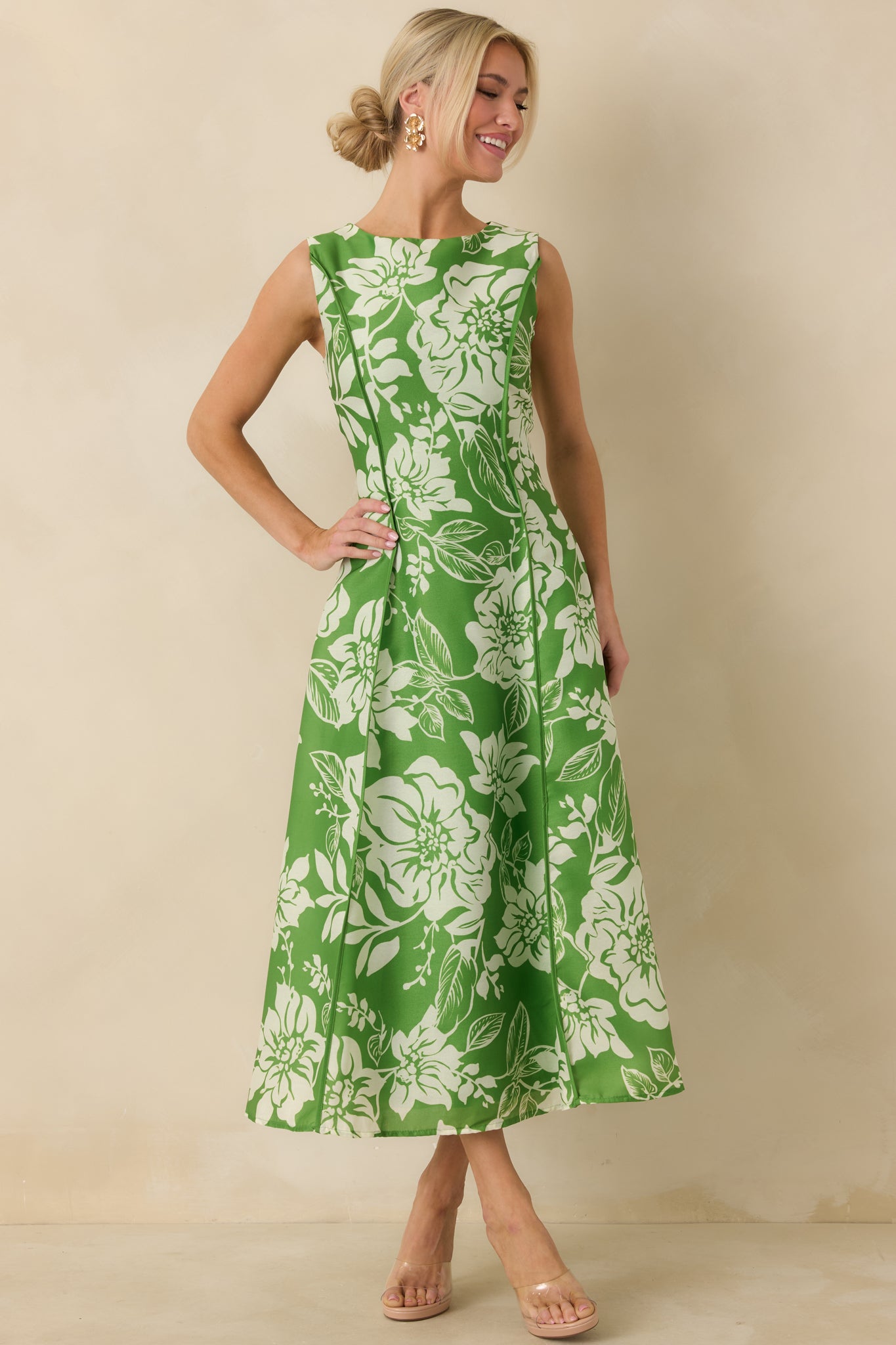 Front-facing view emphasizing the sleeveless cut, clean round neckline, and flowing skirt with subtle movement.