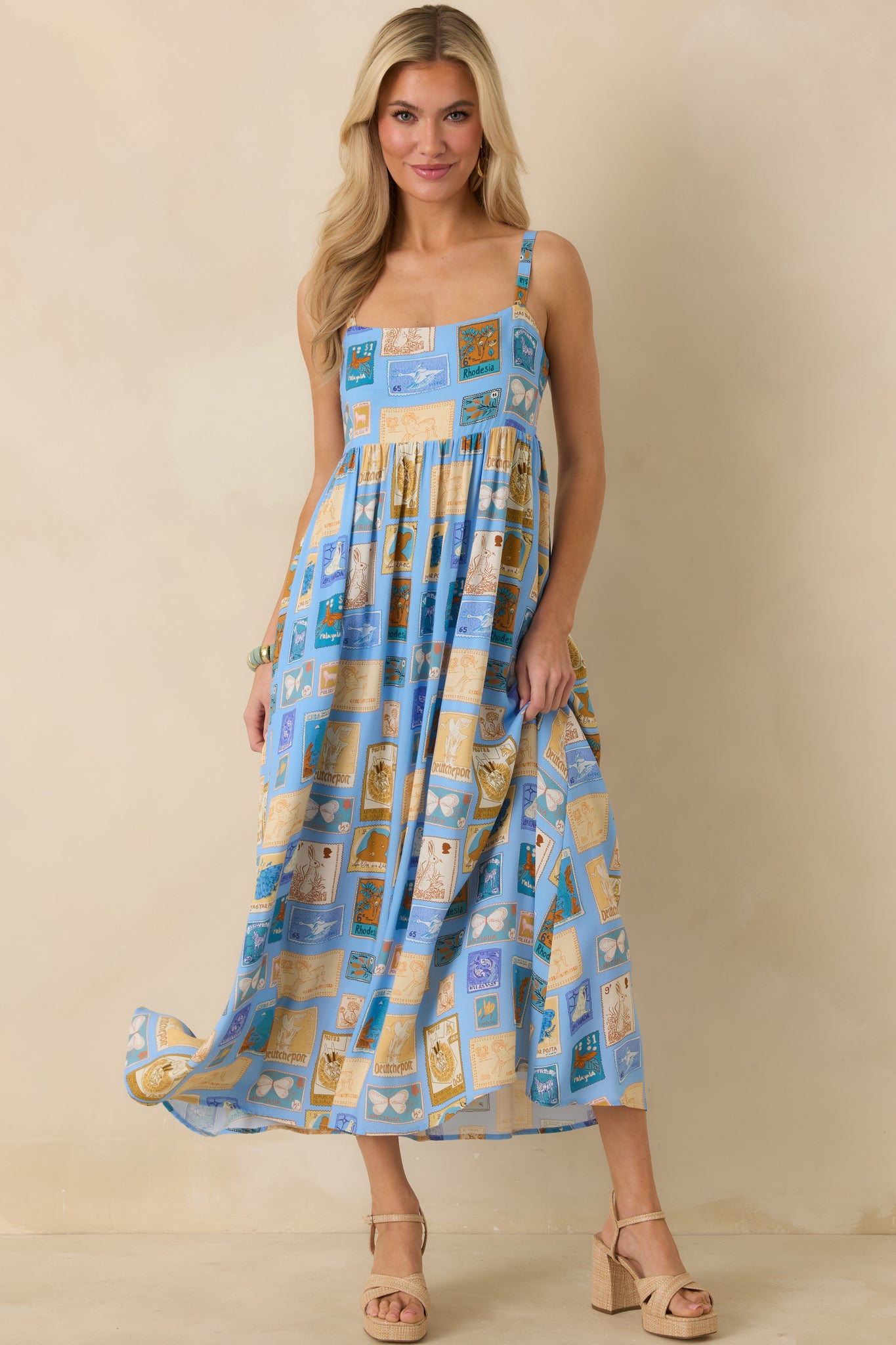 Front-facing view emphasizing the wide straps, square neckline, and gently flared midi-length skirt.