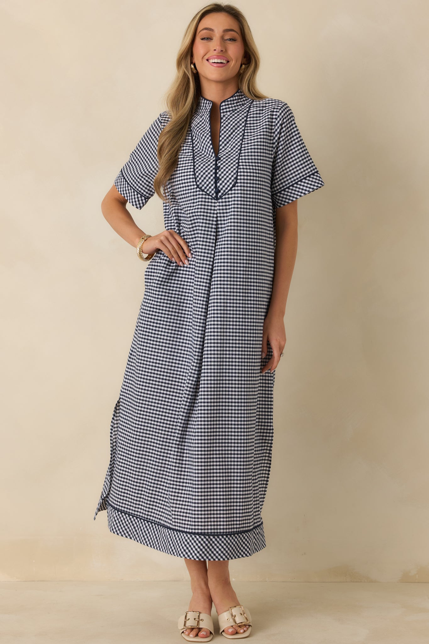 Full-length front view of the navy gingham maxi dress featuring a soft V-neck, short sleeves, and fluid movement.