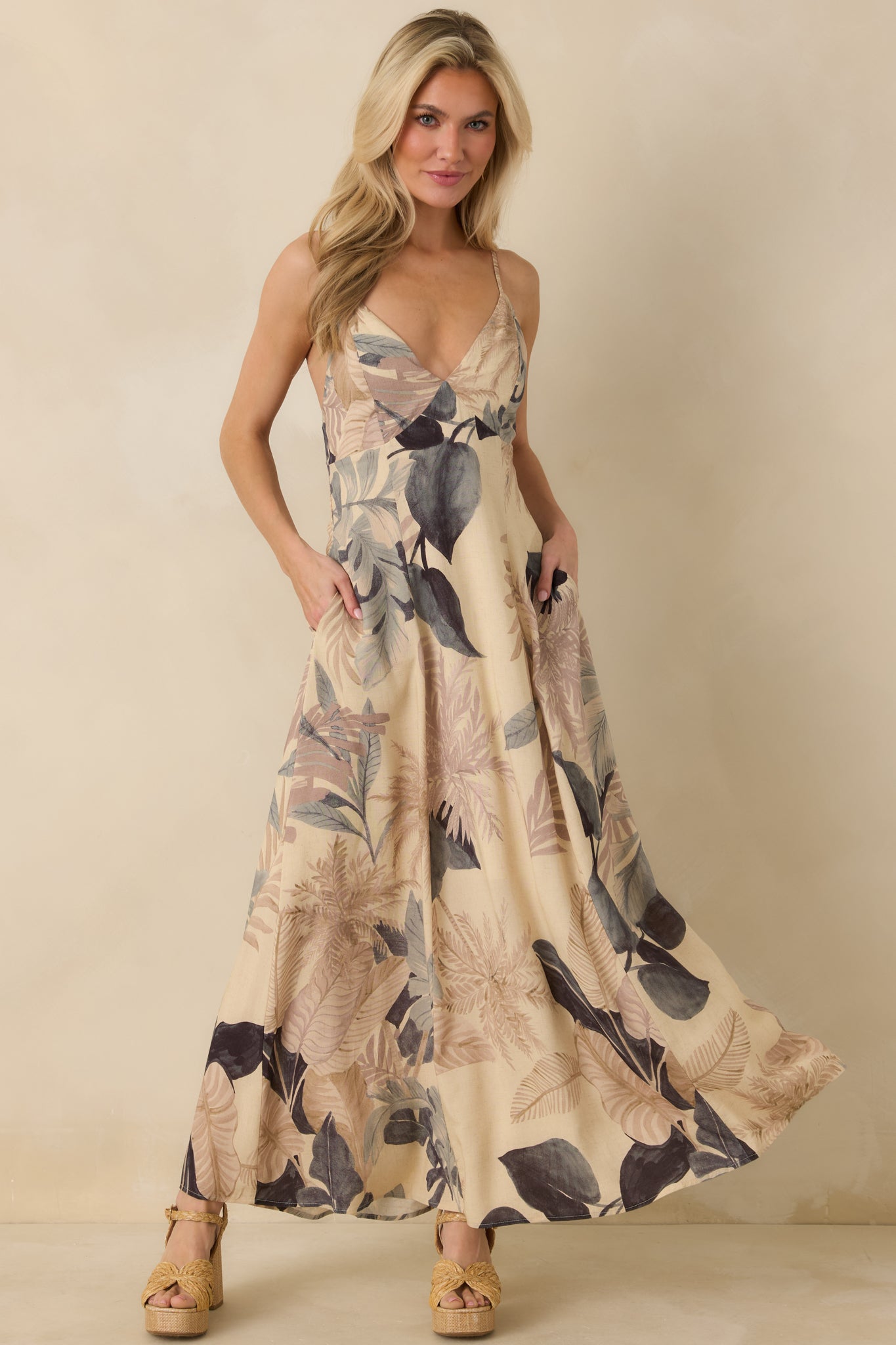 Front view of beige tropical print maxi dress featuring relaxed silhouette and functional side pockets.