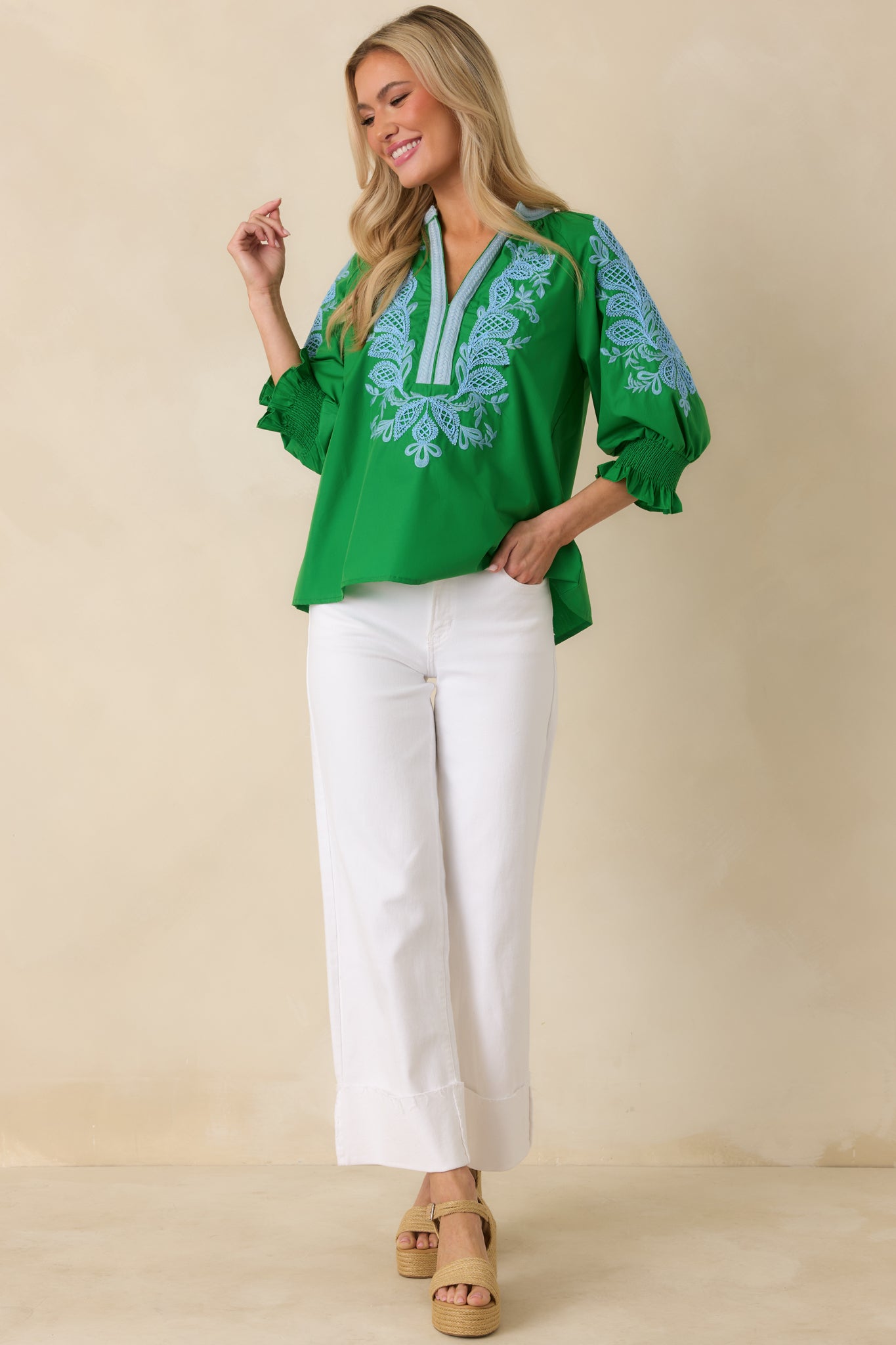 Front view of green V-neck top highlighting the elastic-cuff puff sleeves and intricate embroidery.