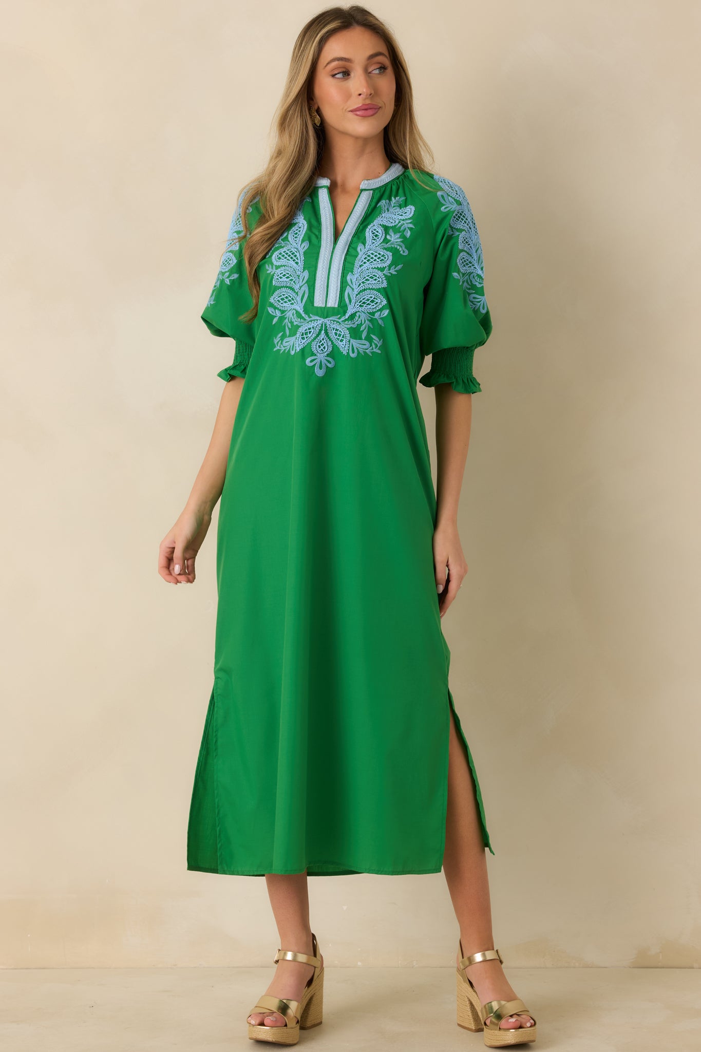 Front view of green woven maxi dress highlighting the split V-neckline and embroidered bodice.