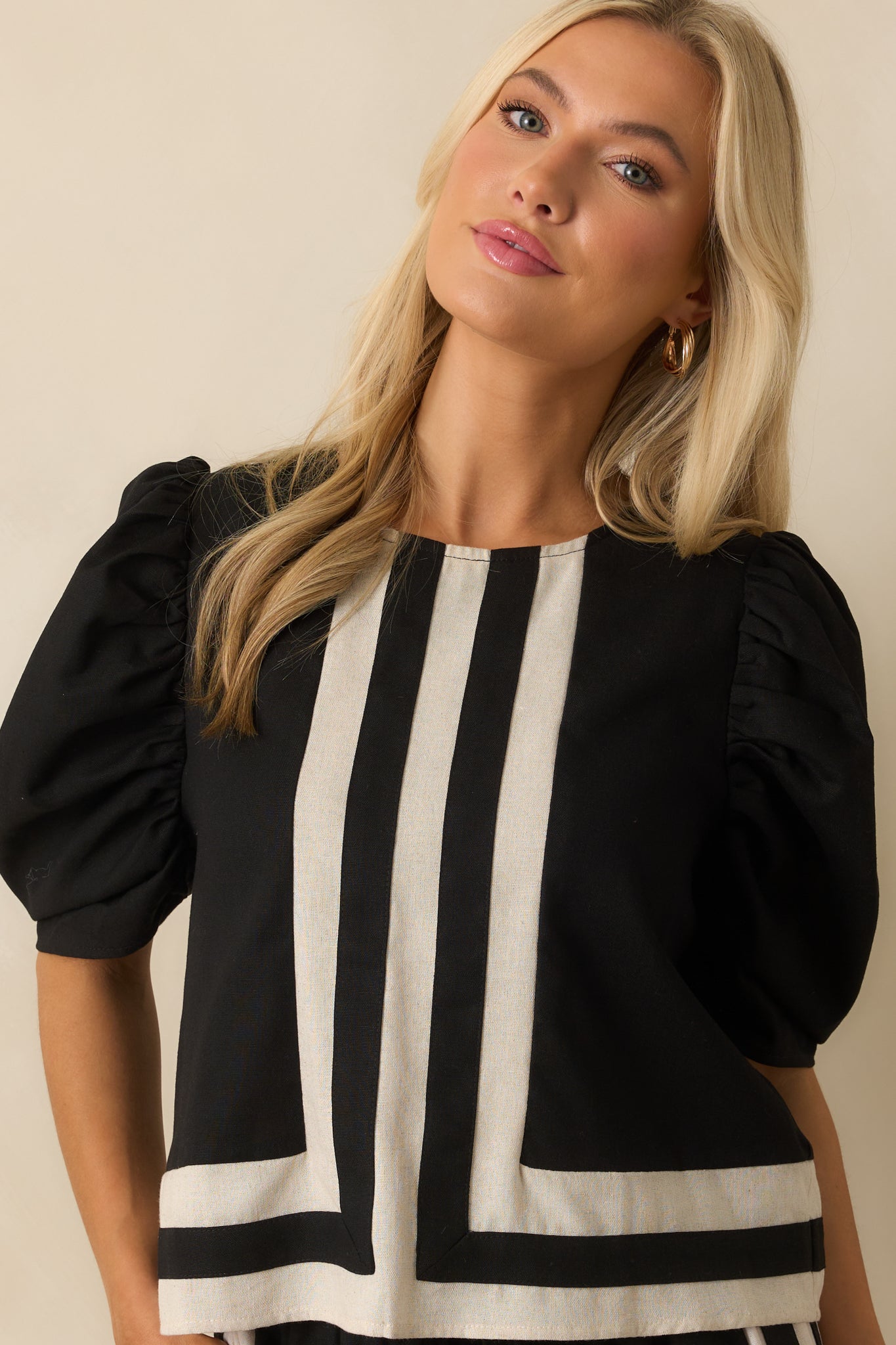 Front view highlighting the black top’s smooth texture and crisp ivory-trimmed neckline.