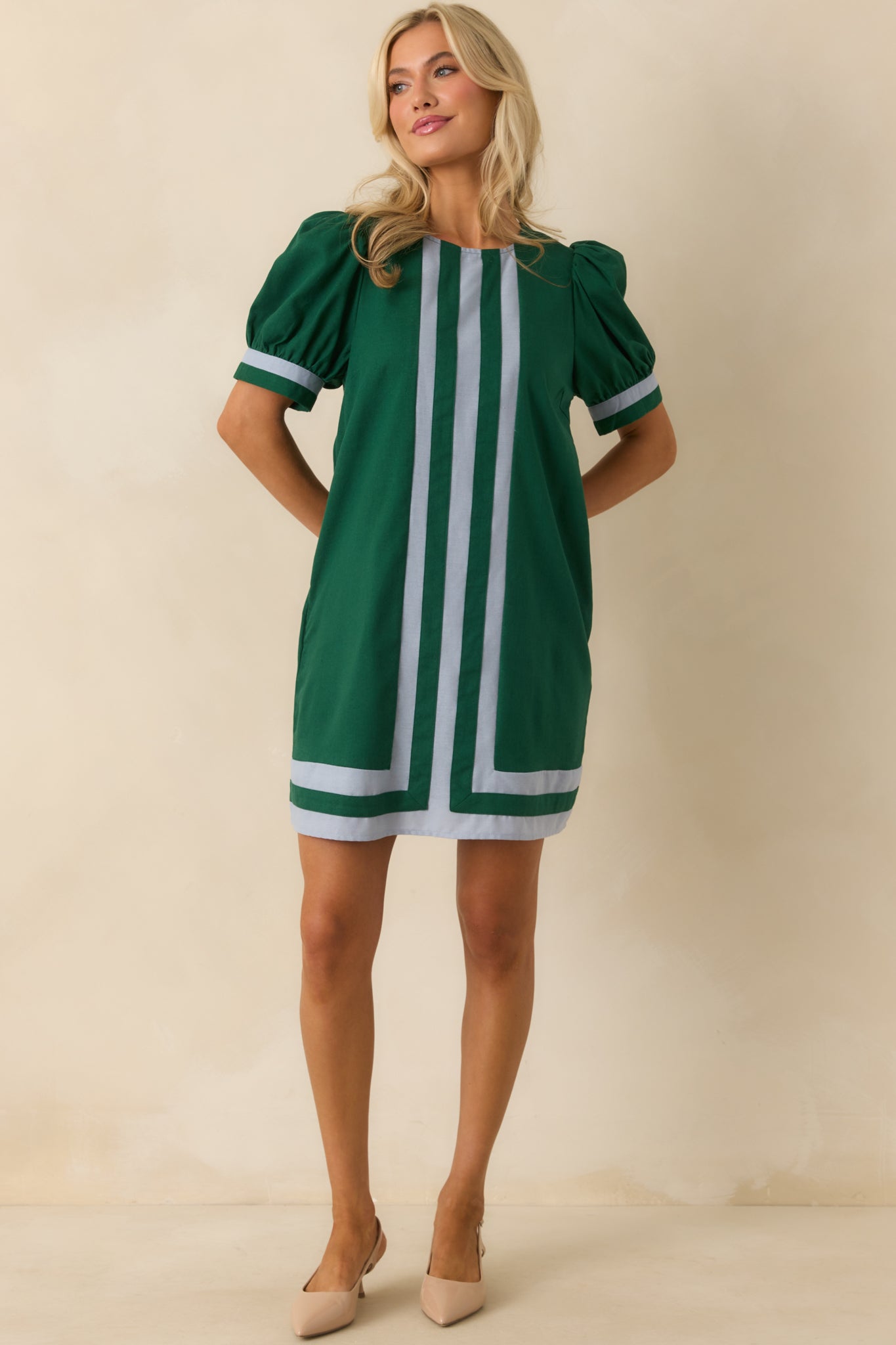Front-facing hunter green dress highlighting lightweight fabric, puff sleeves, blue trim accents, and mini length silhouette.