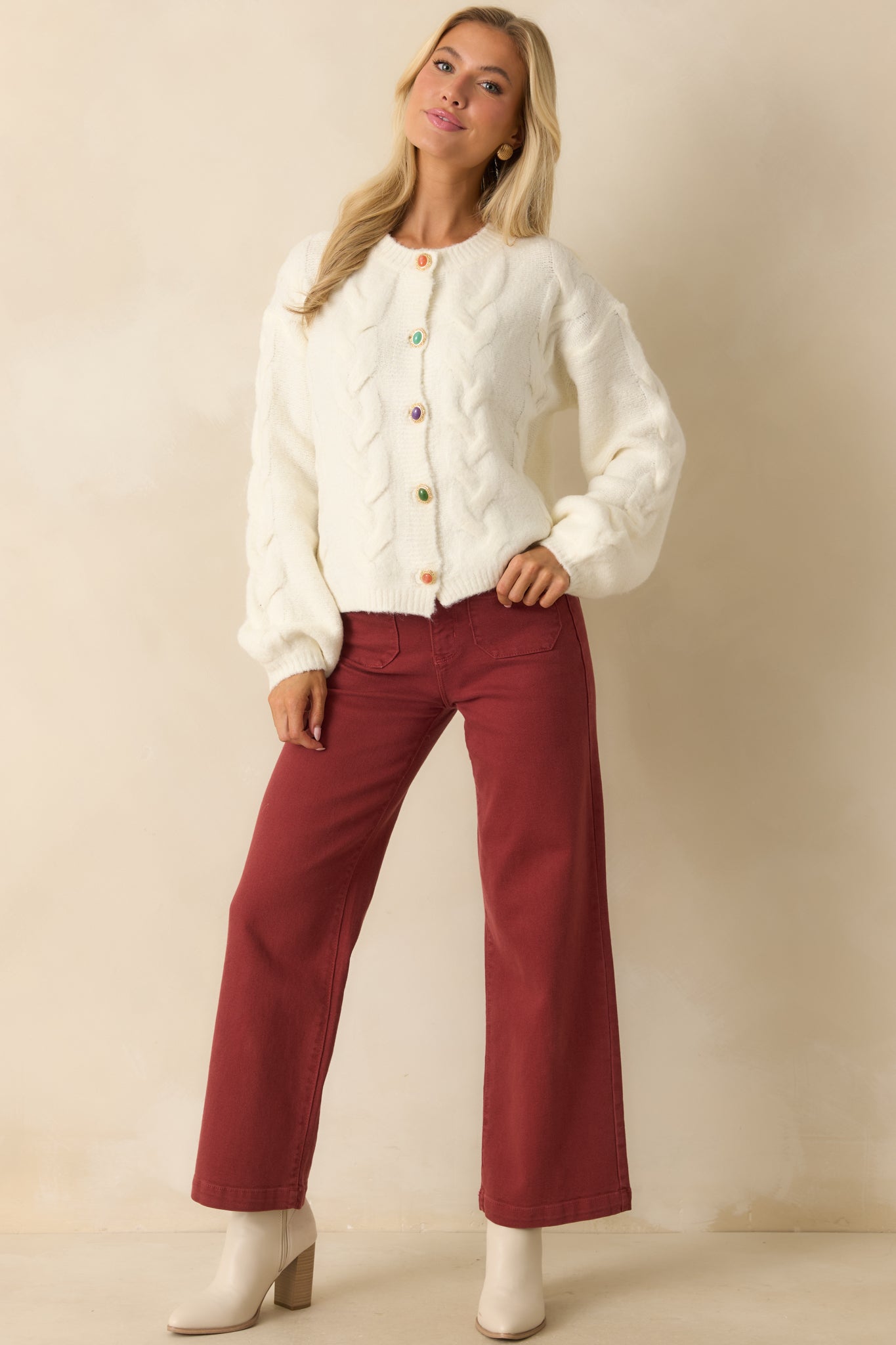 Front-facing ivory cardigan with cozy midweight yarn, decorative multicolor button closures, and a relaxed silhouette.