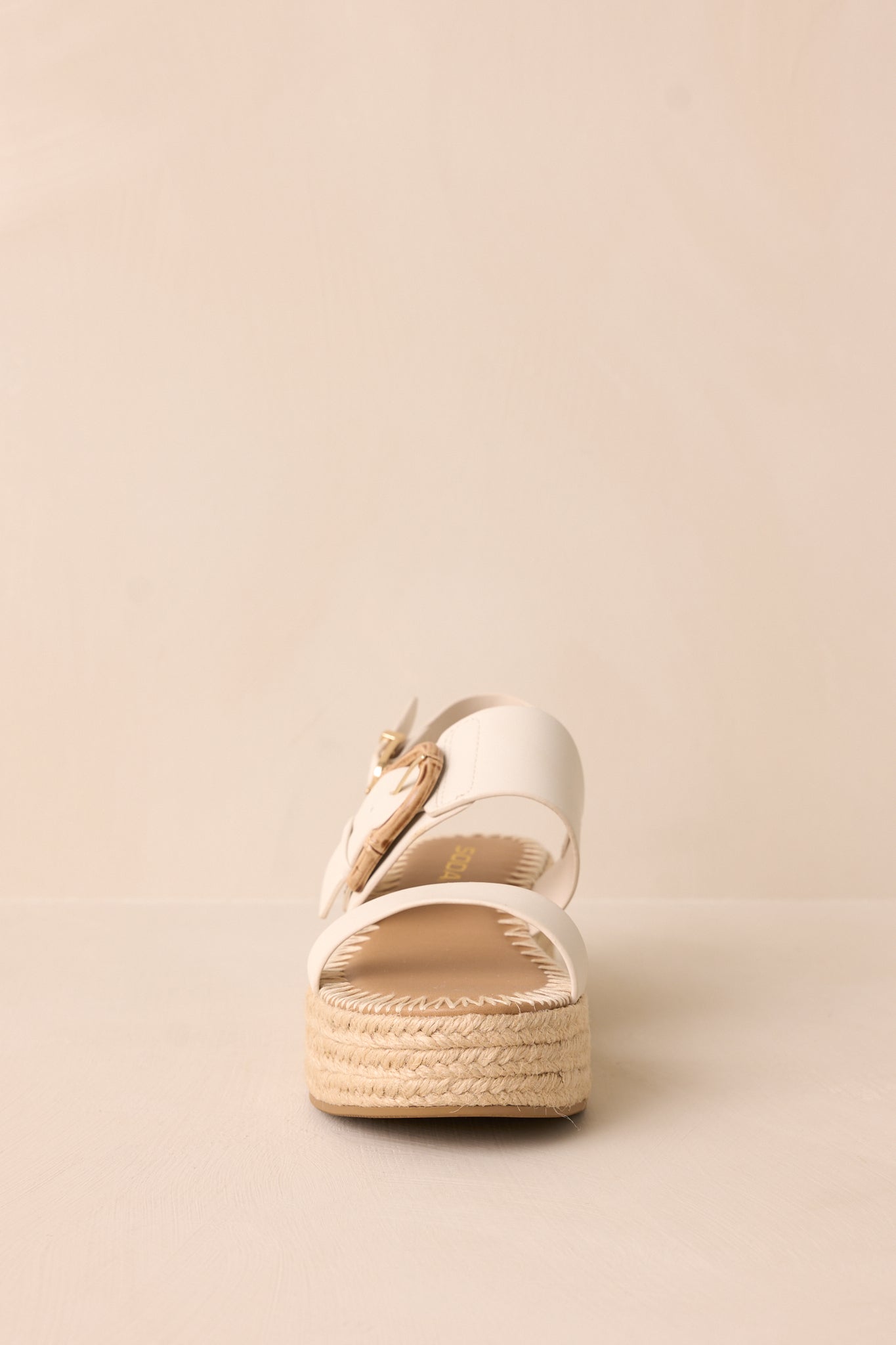 A front-facing look at the ivory sandals, showcasing the rounded toe design and sleek ivory straps.
