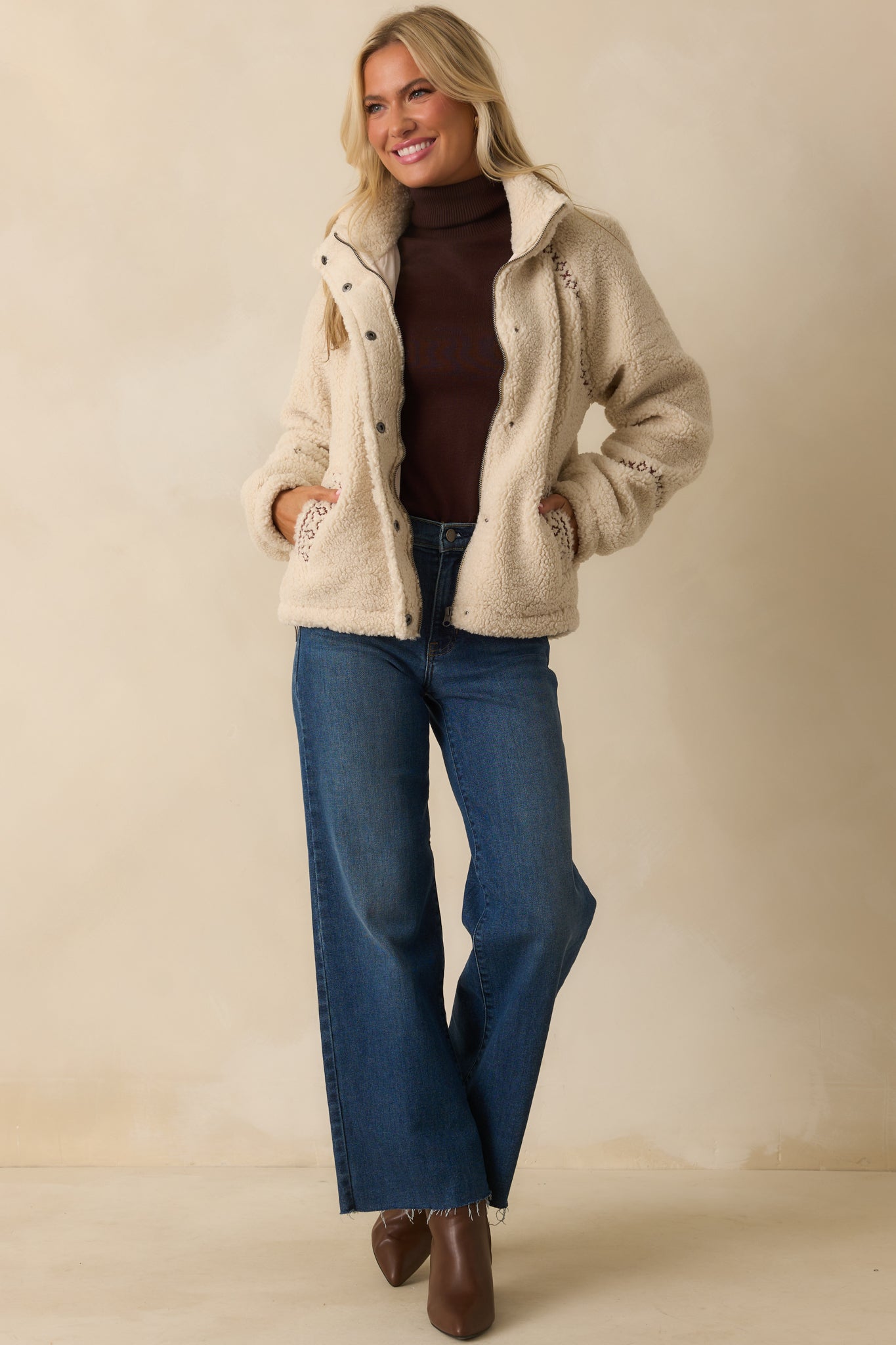 Front view of jacket featuring functional pockets, contrast embroidered trim, and straight hemline.