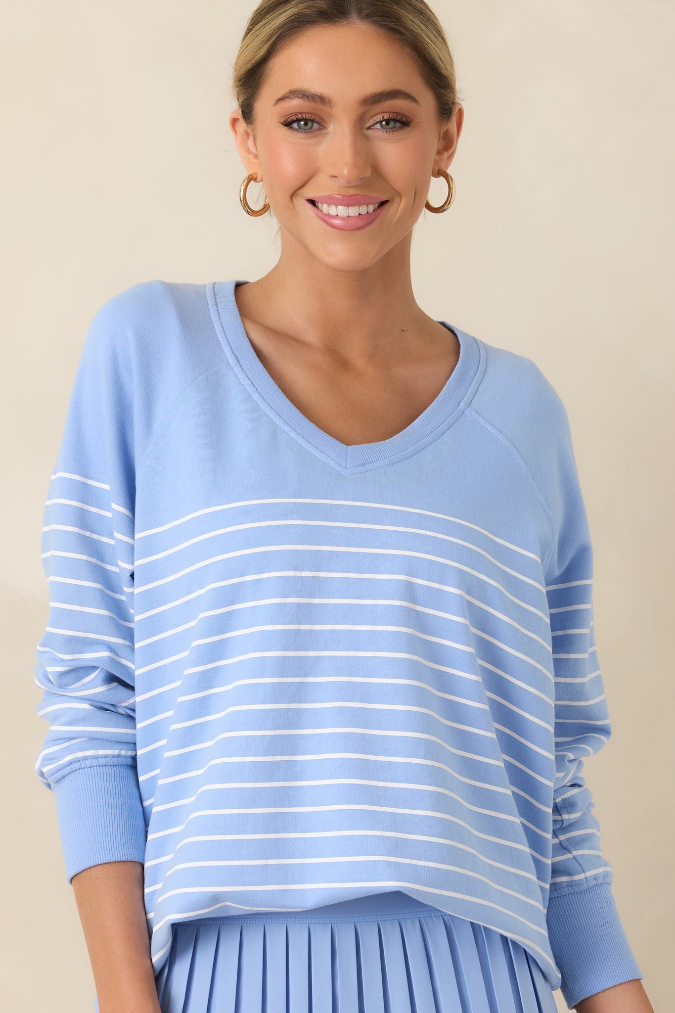 Front-focused view showing ribbed trim at the neckline and cuffs with subtle stripe texture.