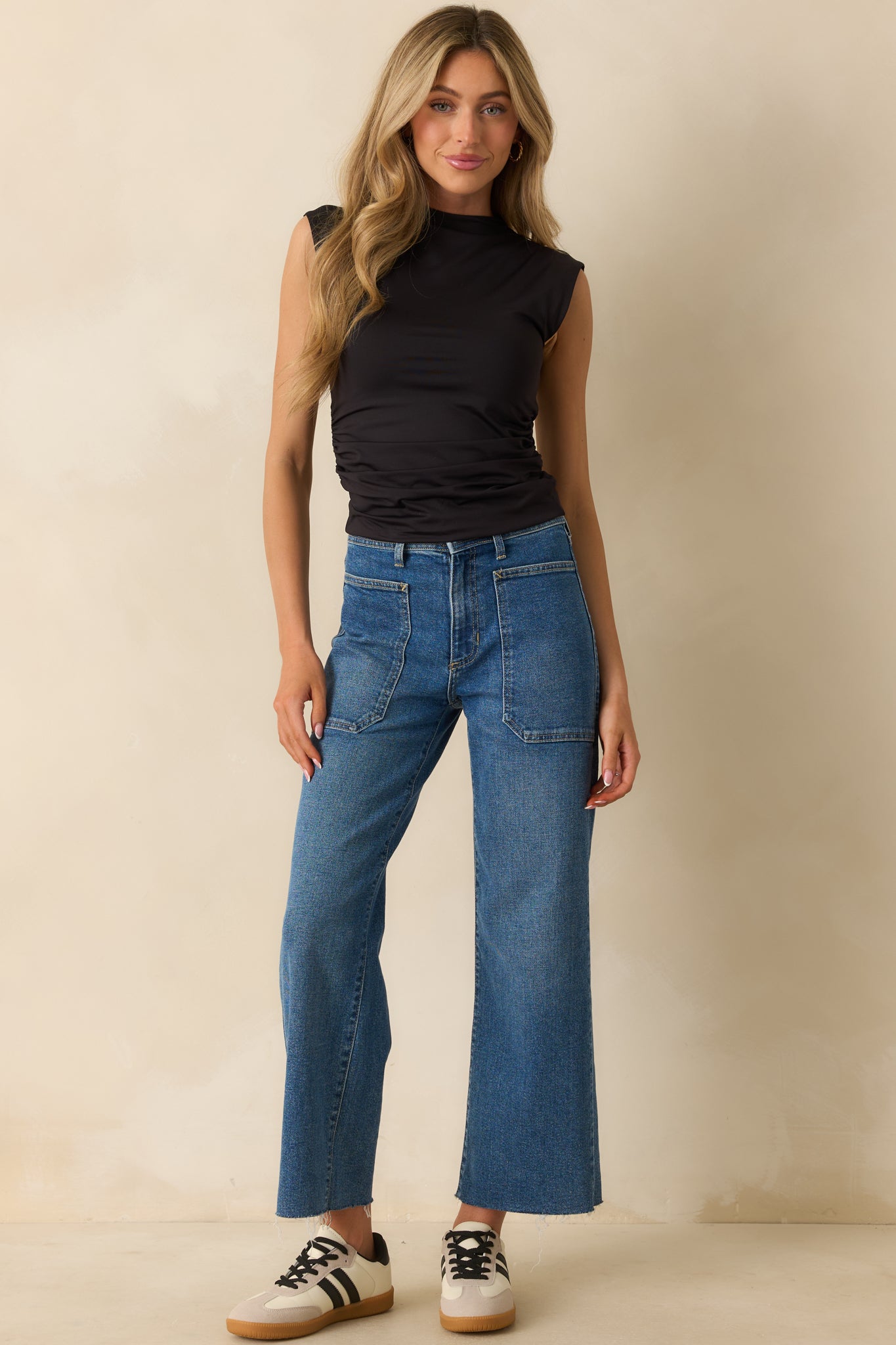 Front view of medium wash jeans featuring functional front patch pockets and belt loops.