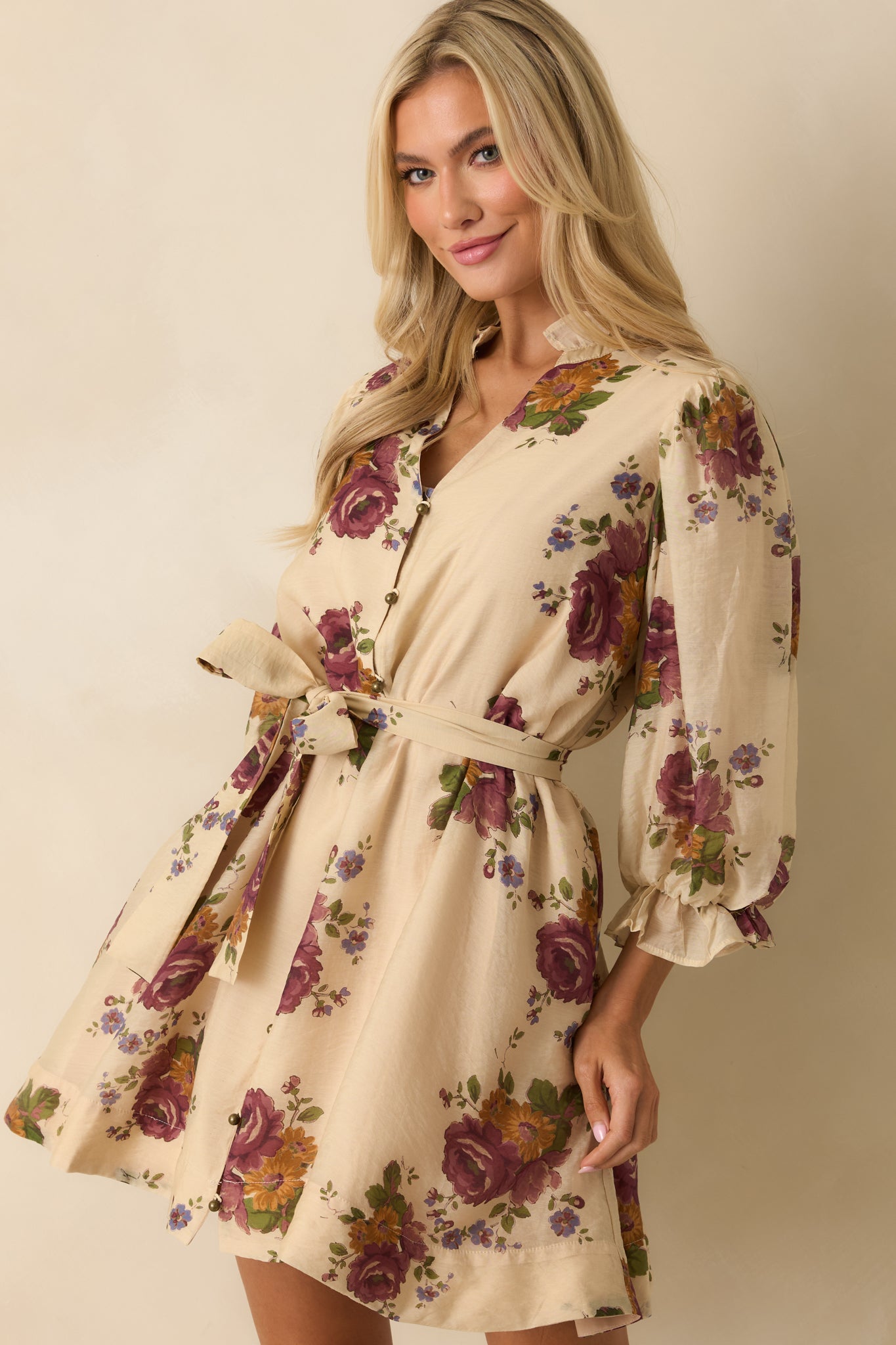 Front-focused shot showing the self-tie waist belt and floral pattern of the mini dress.