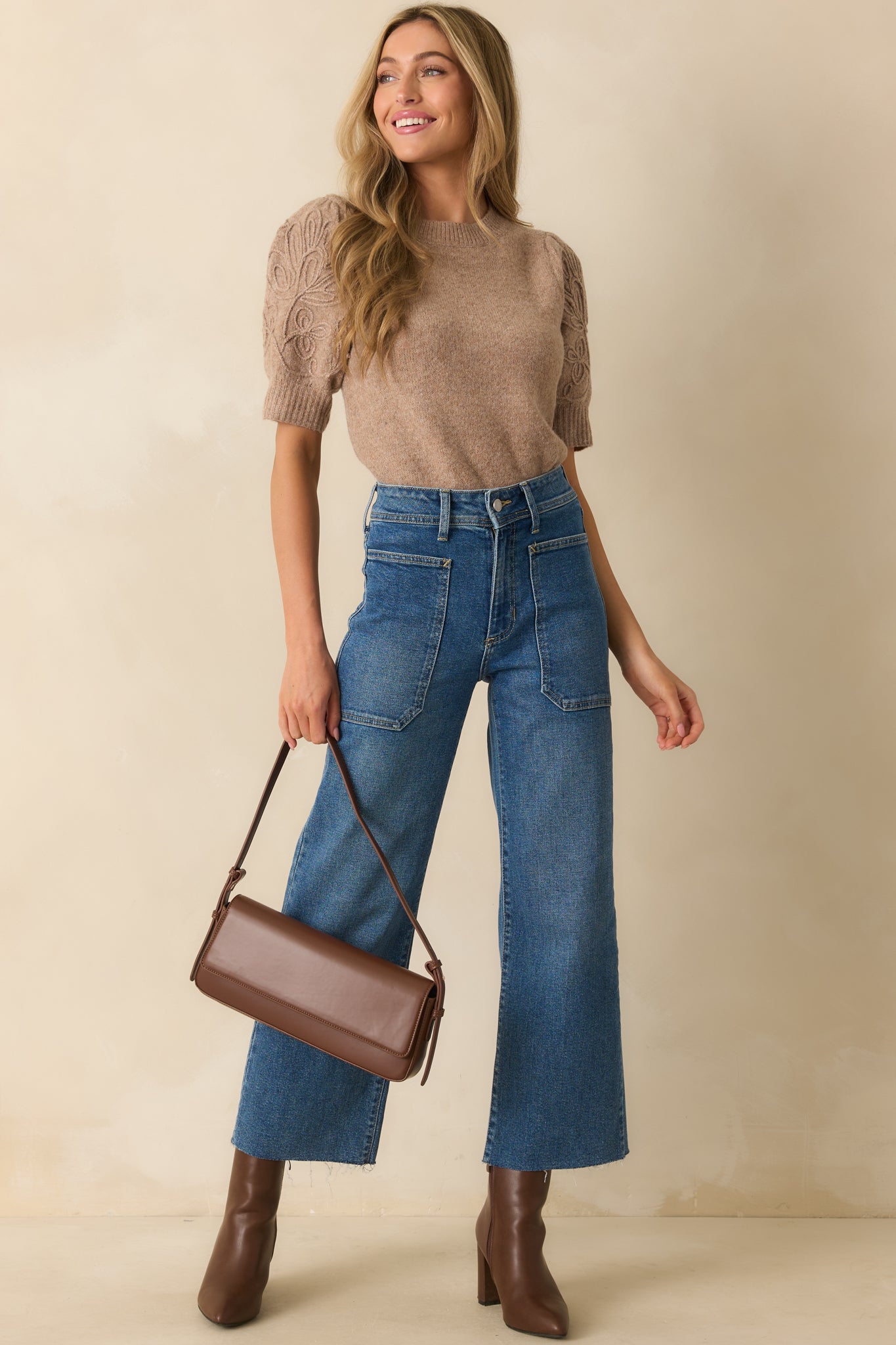 Front-facing mocha knit top emphasizing the short puff sleeves with embroidered scroll accents and polished knit construction.