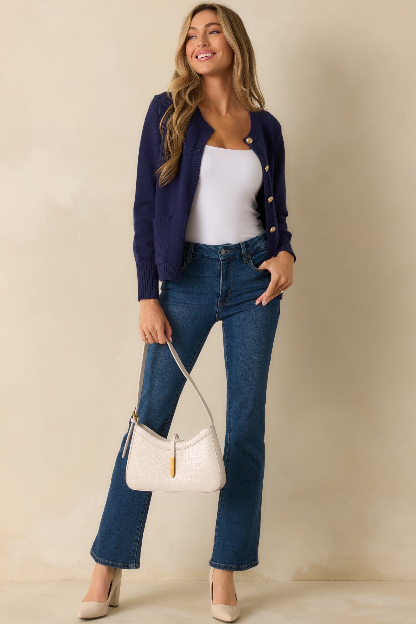 Front view of navy cardigan highlighting ribbed hems, full-length sleeves, and polished button details.