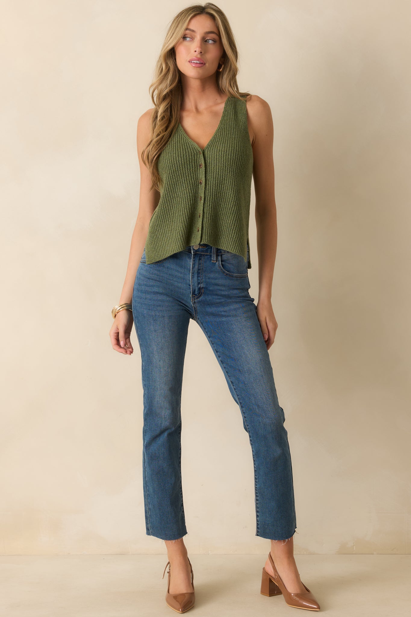 Front view of a knit vest featuring tortoise shell button front and classic v-neck style.