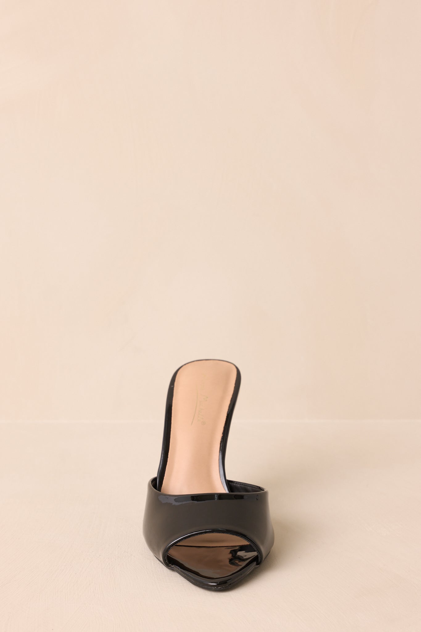 Front view of black heels emphasizing open-toe and structured shape.