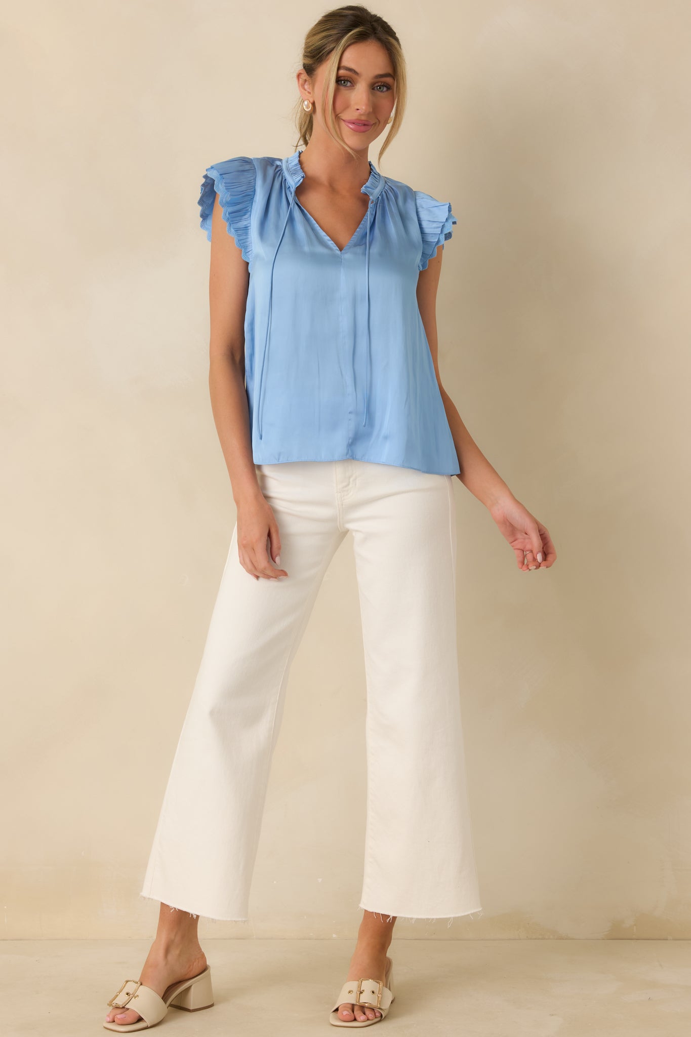 Front-facing view of a blue semi-sheer blouse with ruffle sleeves and a soft flowing silhouette.