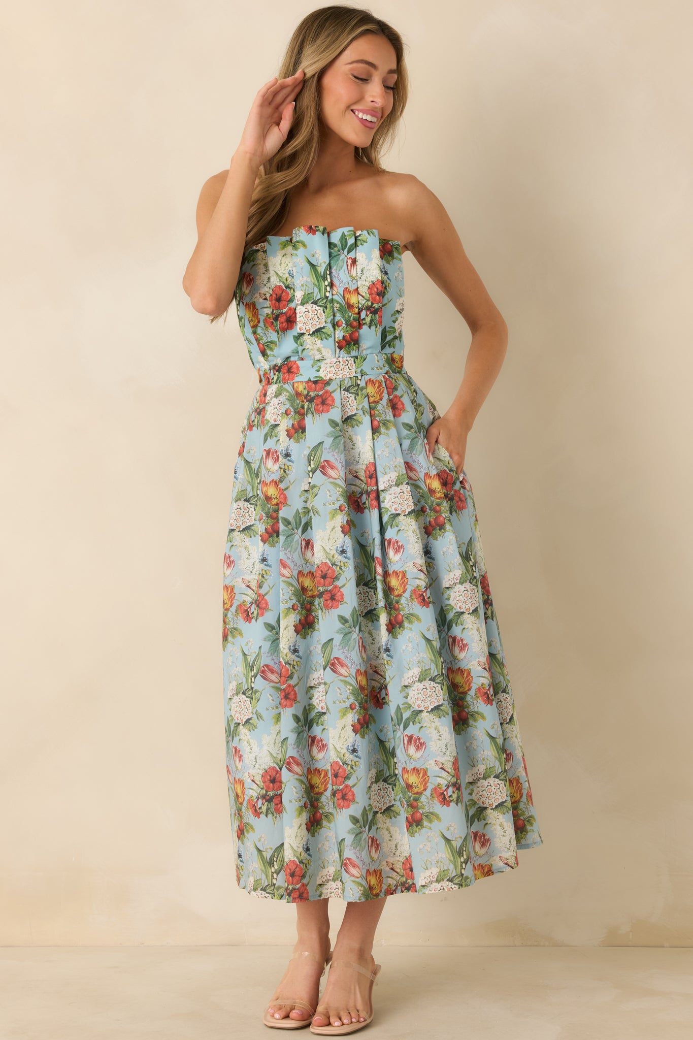 Full front view of blue strapless dress with multicolor floral print and pleated bodice.