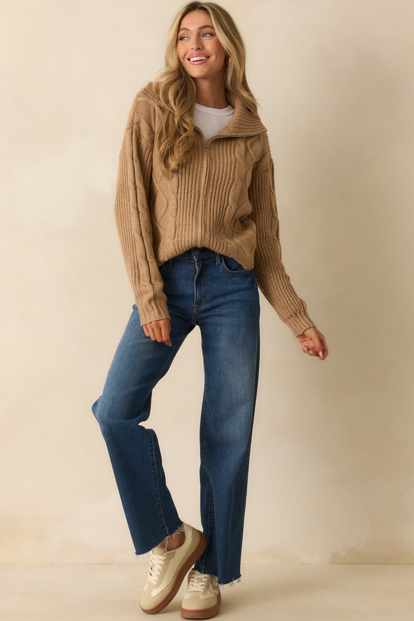 A front view of the camel brown jacket with a fold-over collar, cable knit fabric, and full zip closure.