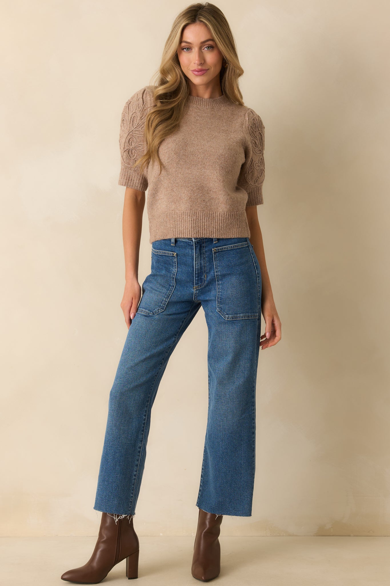 Front view of medium wash utility jeans with high-rise waist, wide-leg silhouette, and raw-cut hem.