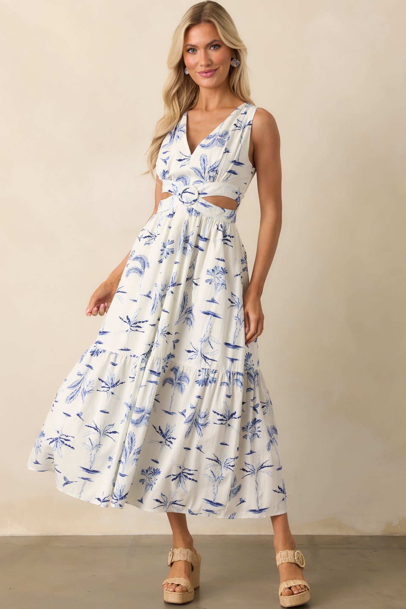 Front view of a maxi dress with a blue watercolor palm tree print on white, featuring a v-neckline and sleeveless design