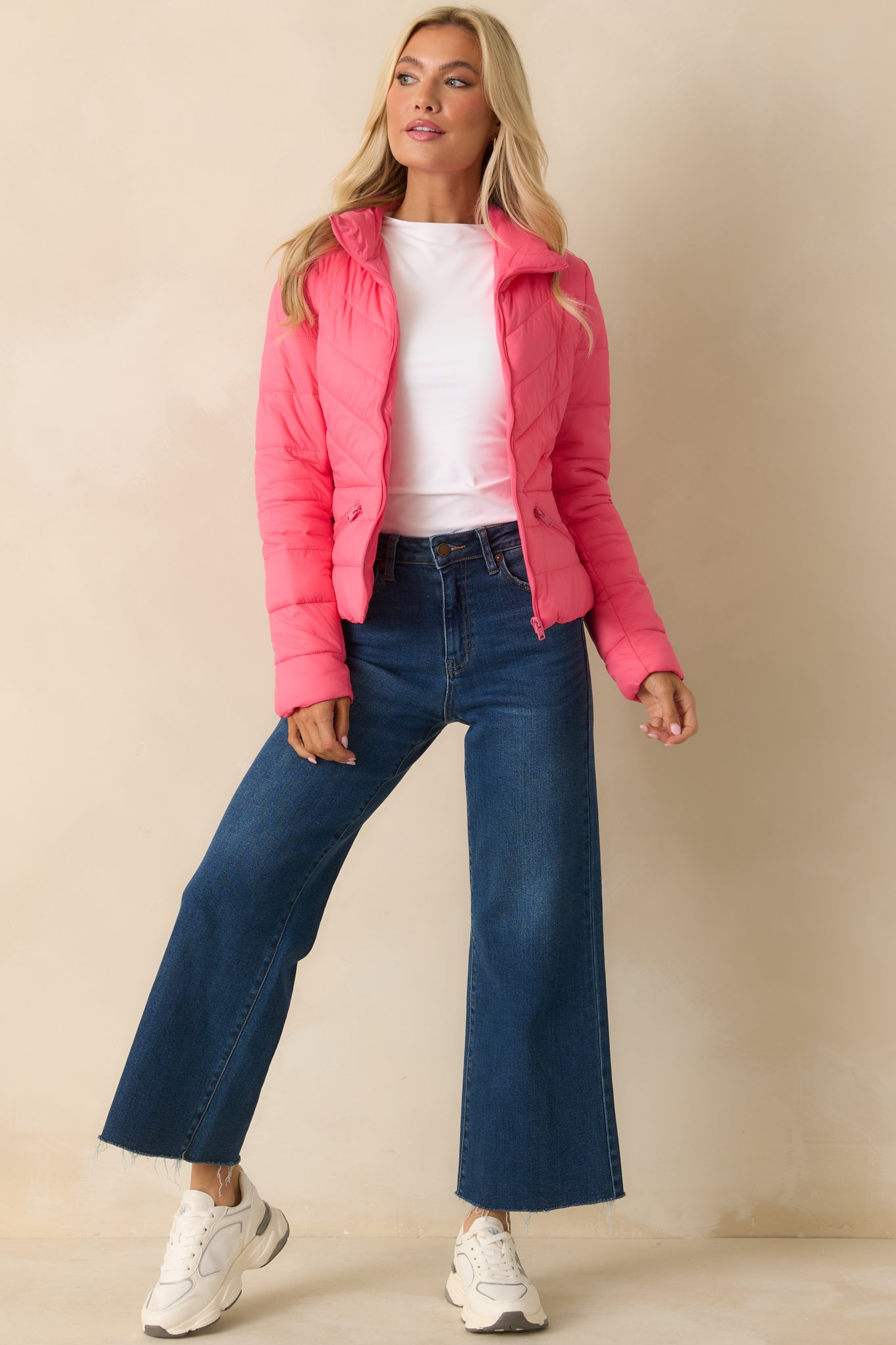 Front view of the bright pink puffer jacket highlighting the high neck, zip front, and diagonal quilting.