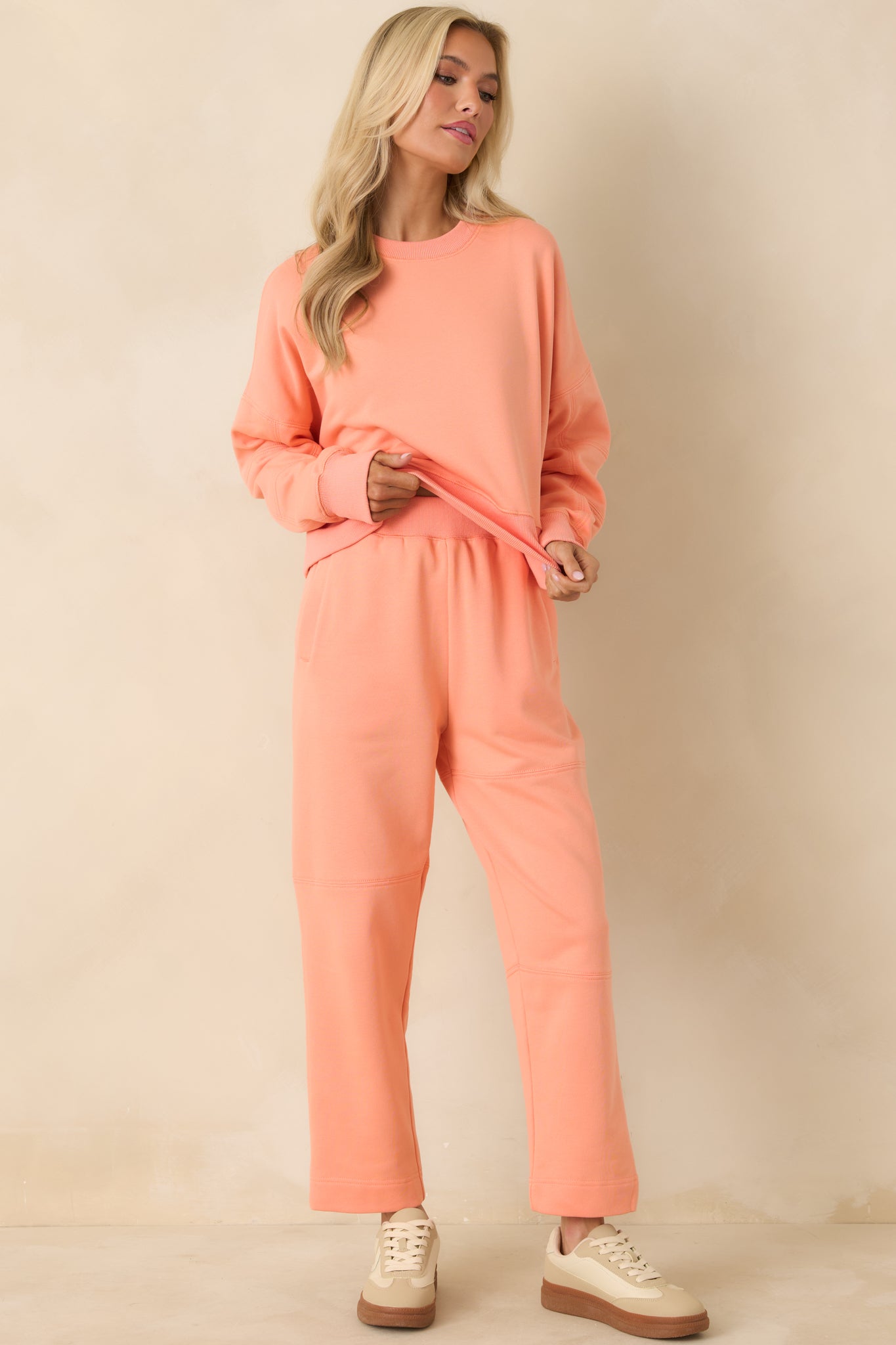Front view of soft knit orange sweatshirt featuring ribbed cuffs and hem.