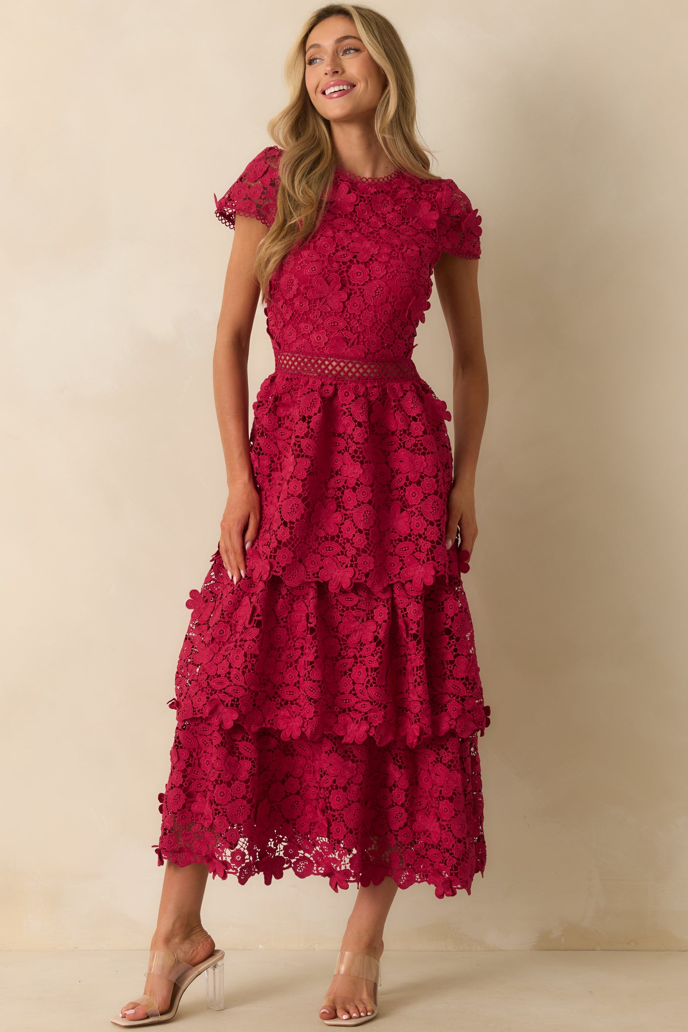 Front view of the red maxi dress showing the fitted bodice, sheer waist detail, and flowing tiered skirt with scalloped hems.