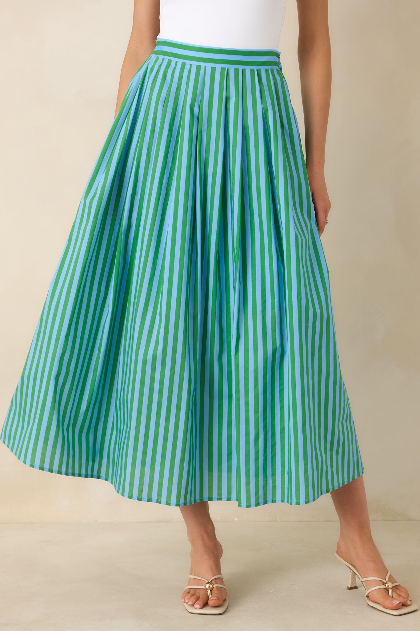 Close front view of the high-rise waistband and vertical blue and green stripe detailing on the maxi skirt.