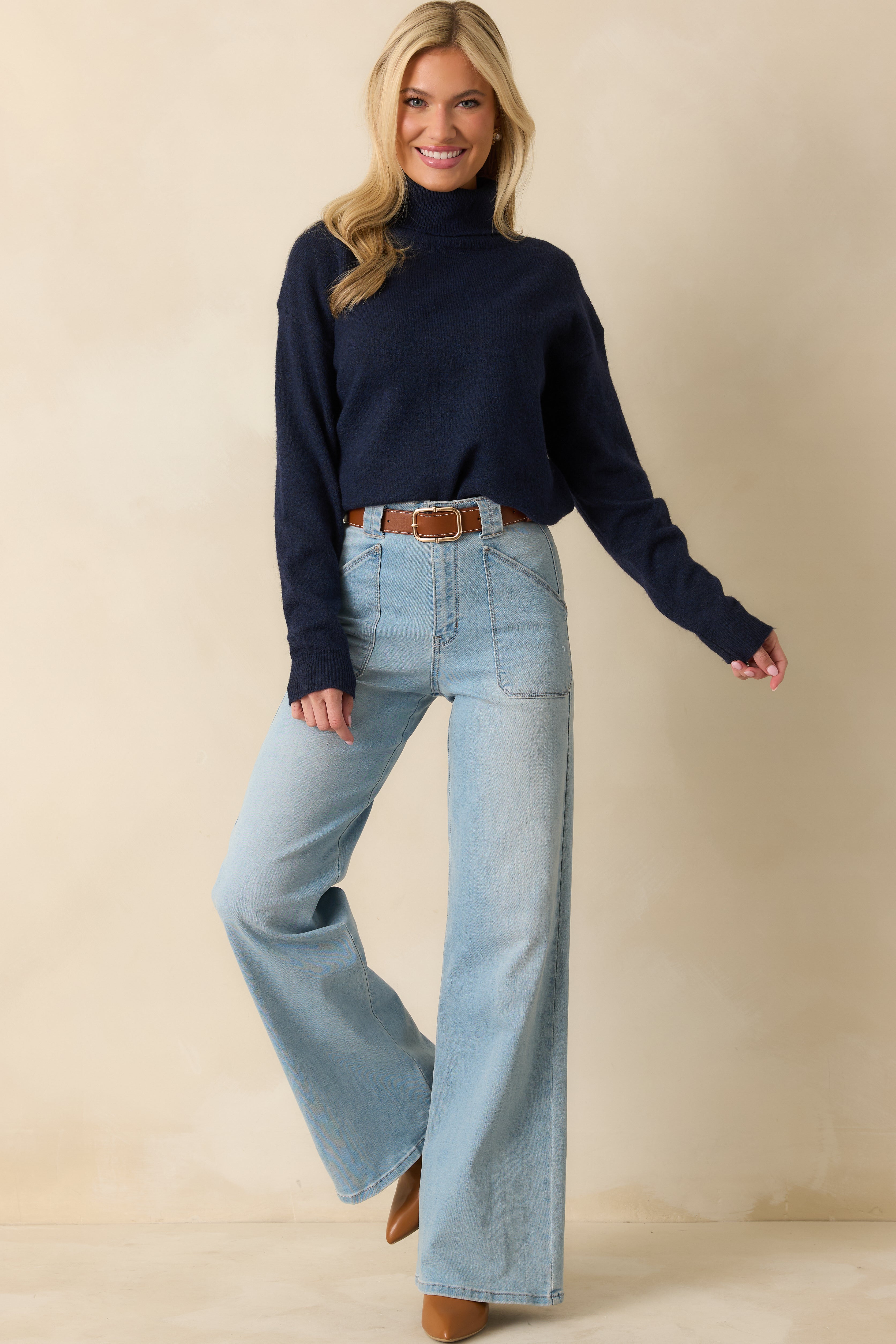Front view of cozy navy knit sweater featuring ribbed cuffs, hem, and turtleneck trim.