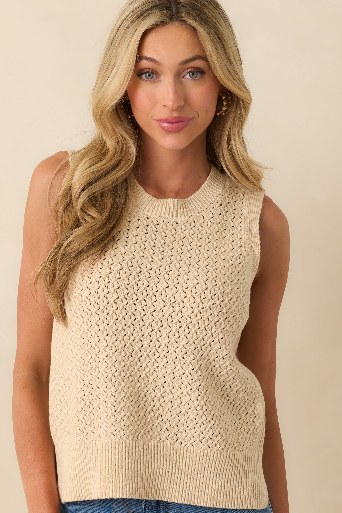 A cropped front view focusing on the neckline and upper chest area of the open knit fabric.