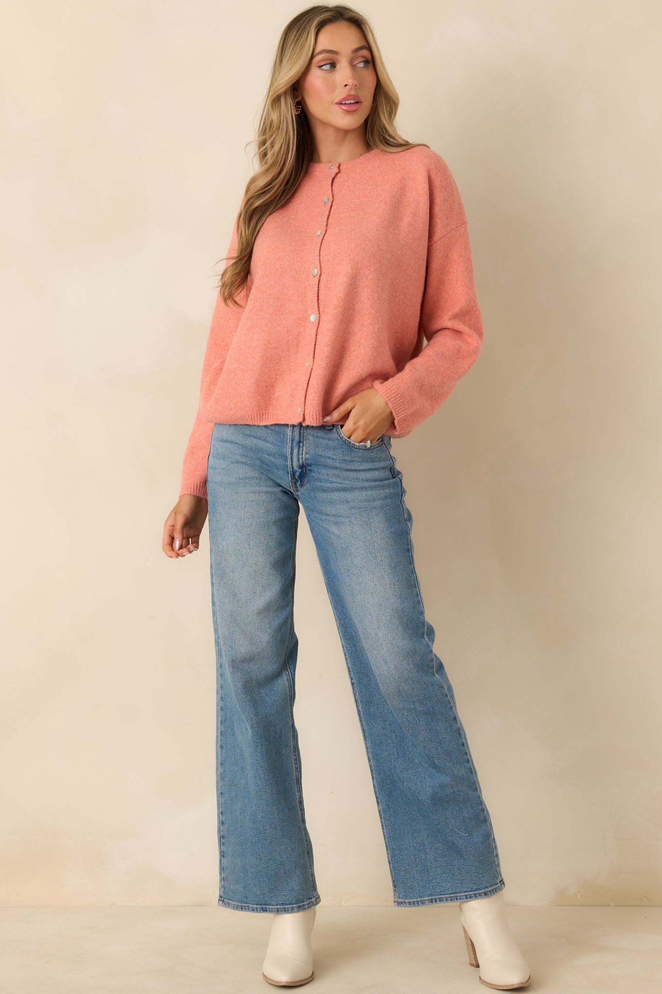 Full body front view of the orange knit cardigan showing the button-front closure, round neckline, and relaxed fit.