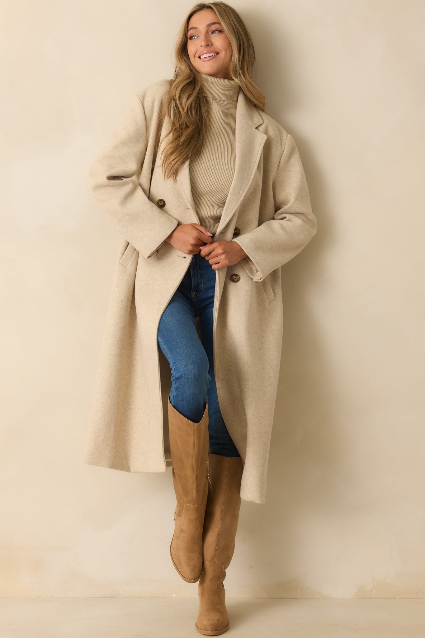 Front view of longline coat highlighting smooth fabric, double-breasted closure, and classic tailored fit.