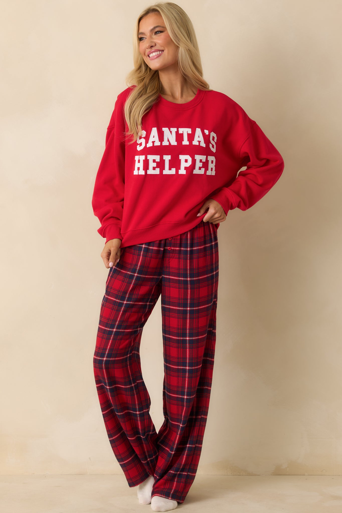 Front view of oversized red sweatshirt with long sleeves, crew neck, and holiday-themed applique.