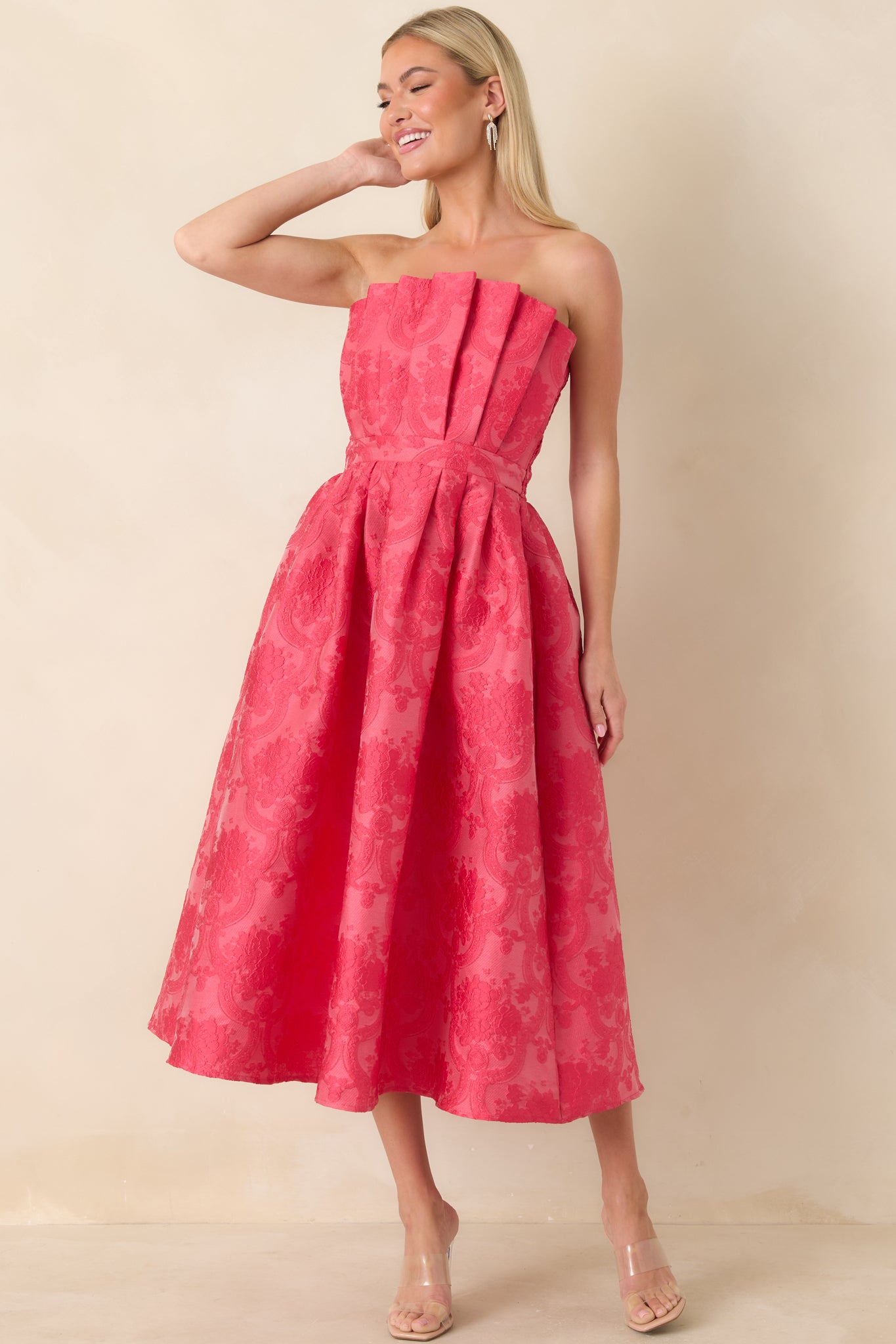 Straight-on front view of pink jacquard midi dress featuring a strapless neckline and refined pleated detailing.