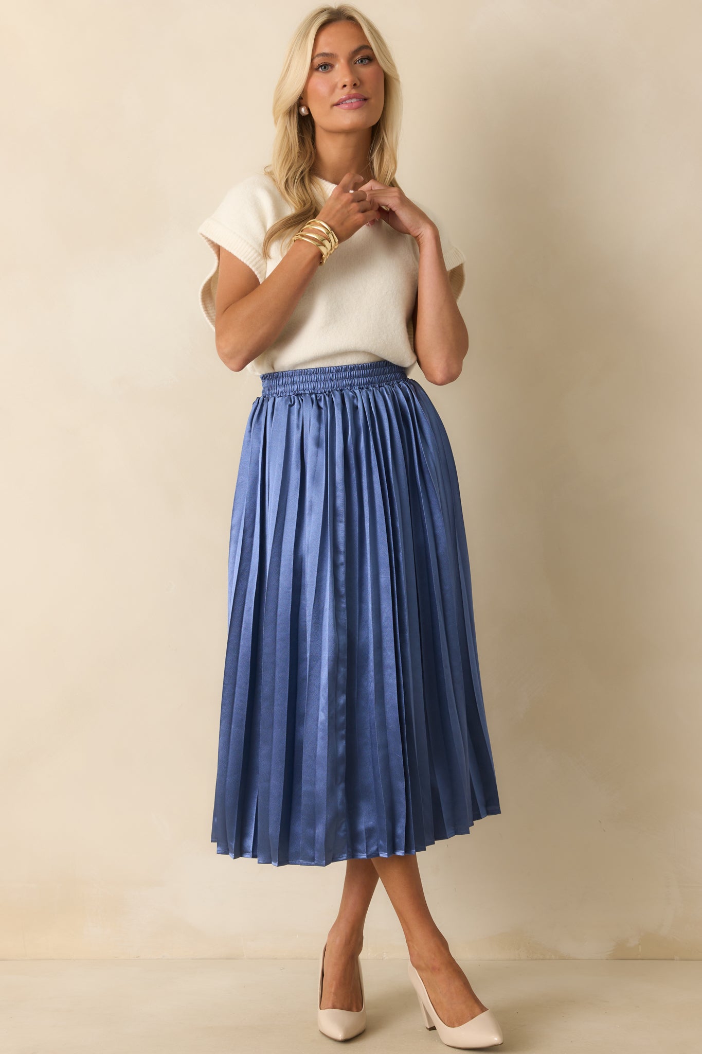 A front-facing image highlighting the pleated fabric and flowing silhouette of the midi skirt.
