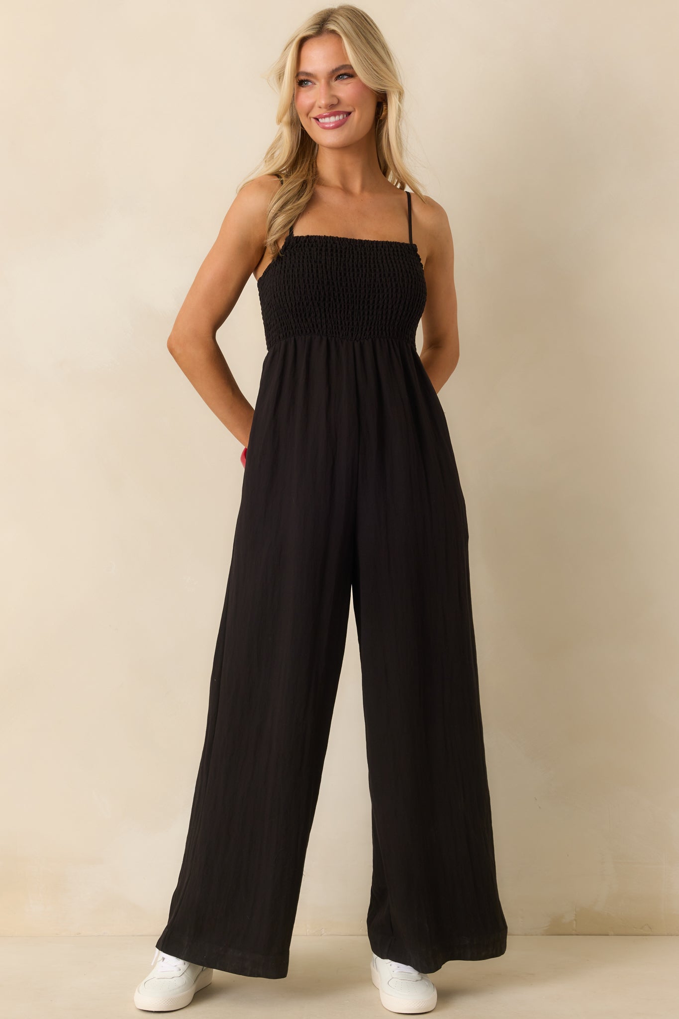 Full body front view showcasing the smocked bodice paired with the loose, wide-leg silhouette of the jumpsuit.