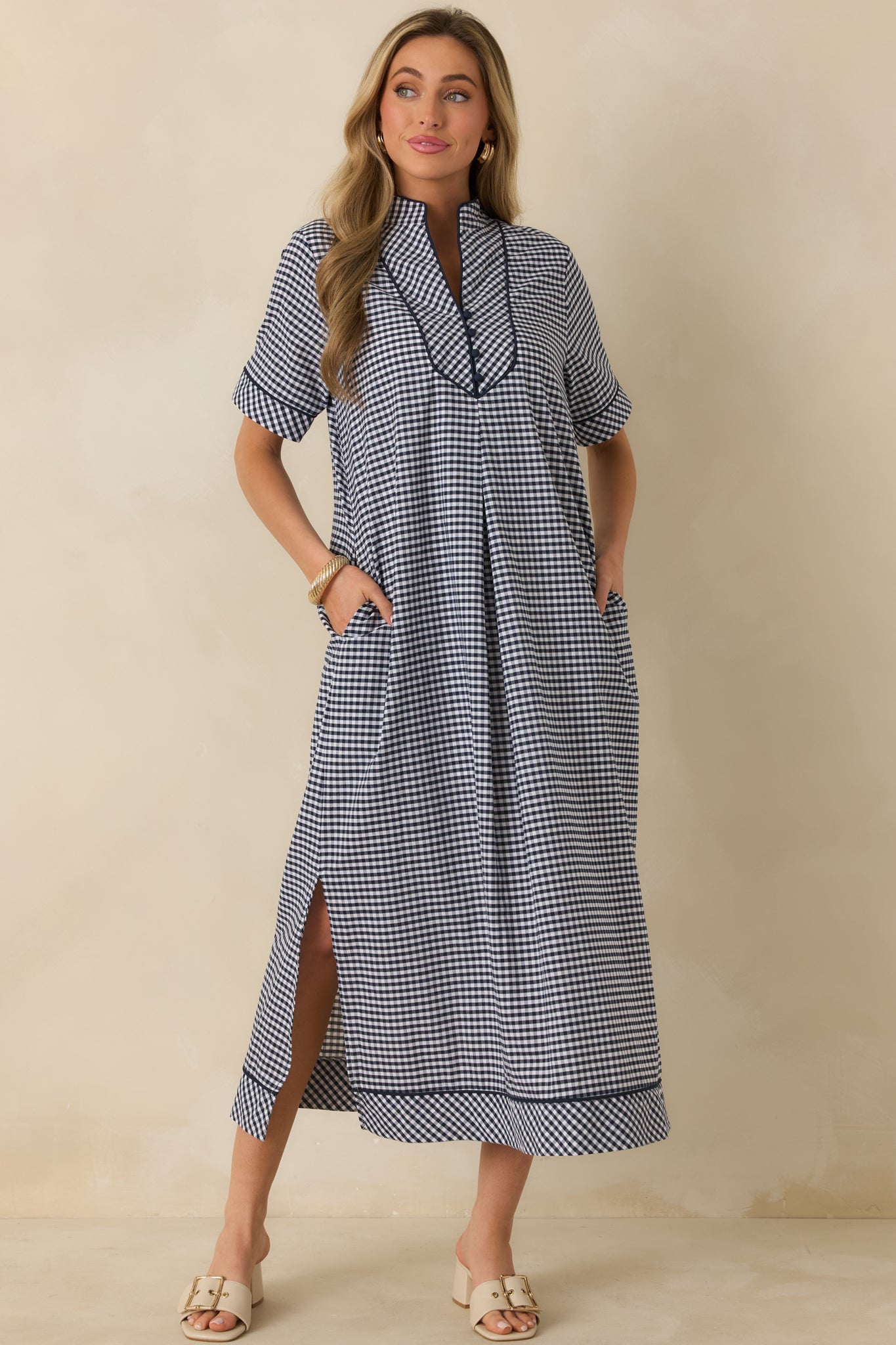 Angled front view showcasing the navy gingham maxi dress with short sleeves, lightweight drape, and clean, polished shape.