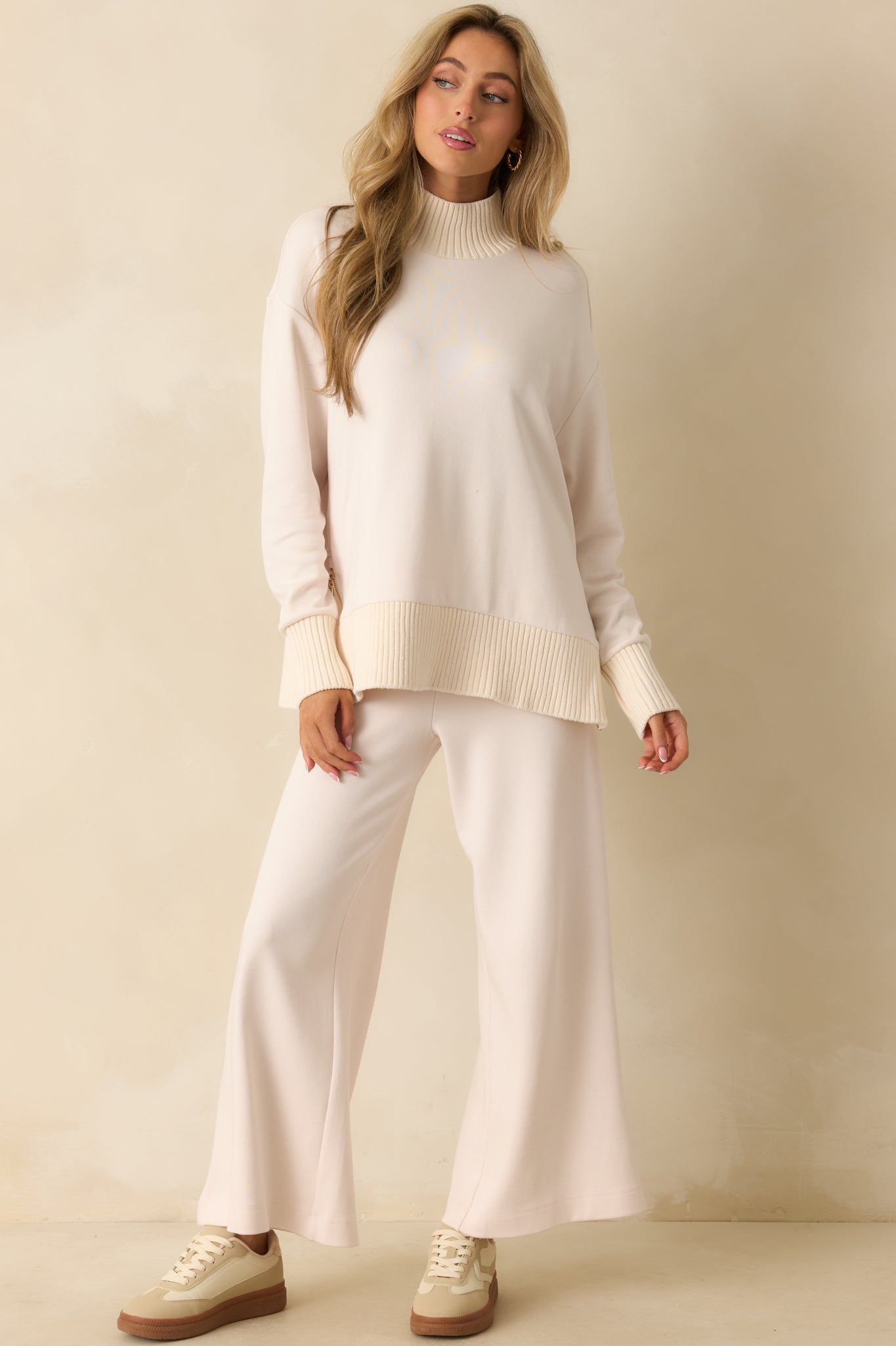 Front view of soft knit ivory sweater featuring ribbed cuffs and hem.