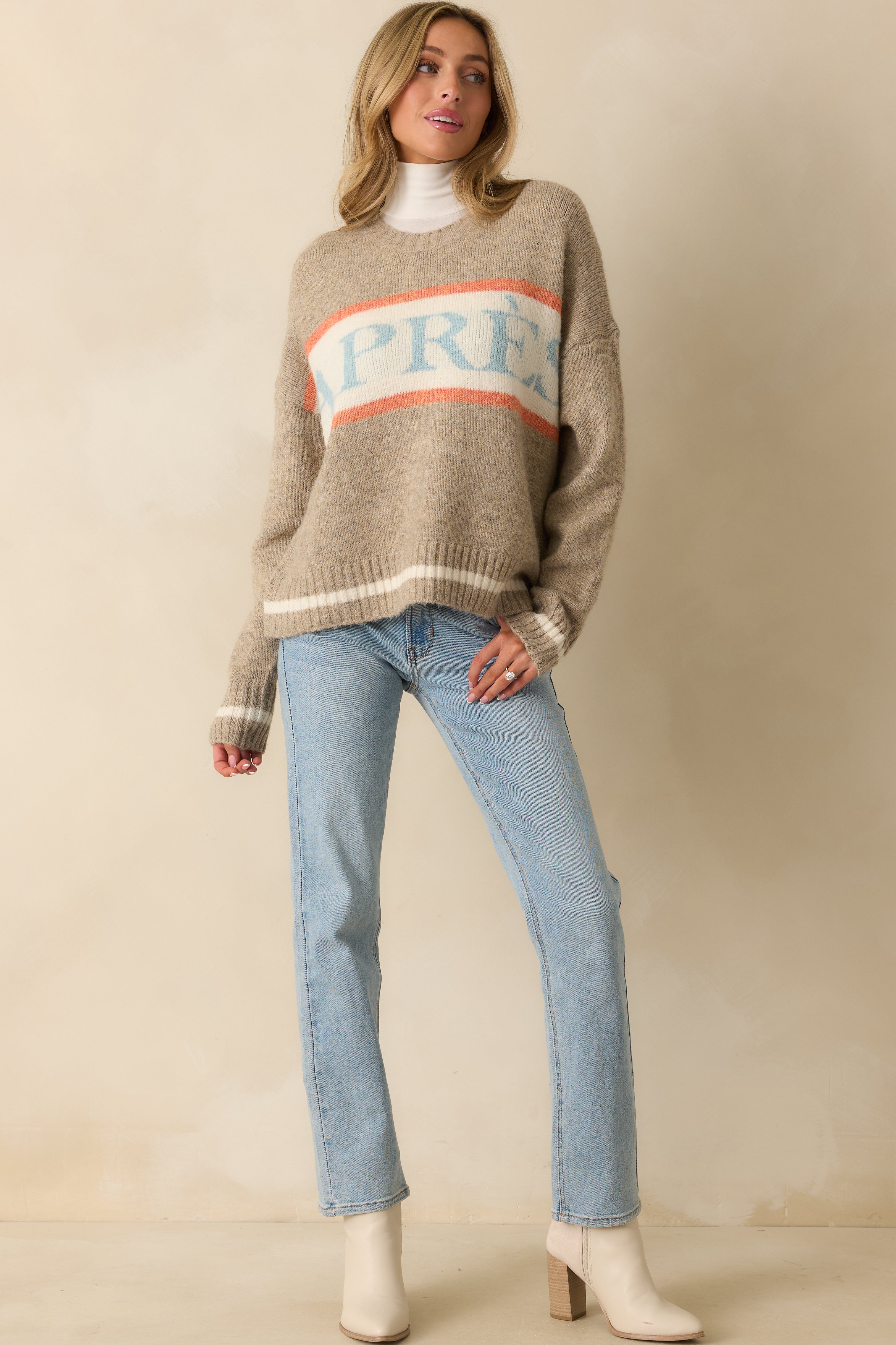 Front view of cozy taupe sweater featuring contrasting orange and ivory stripes and relaxed fit.