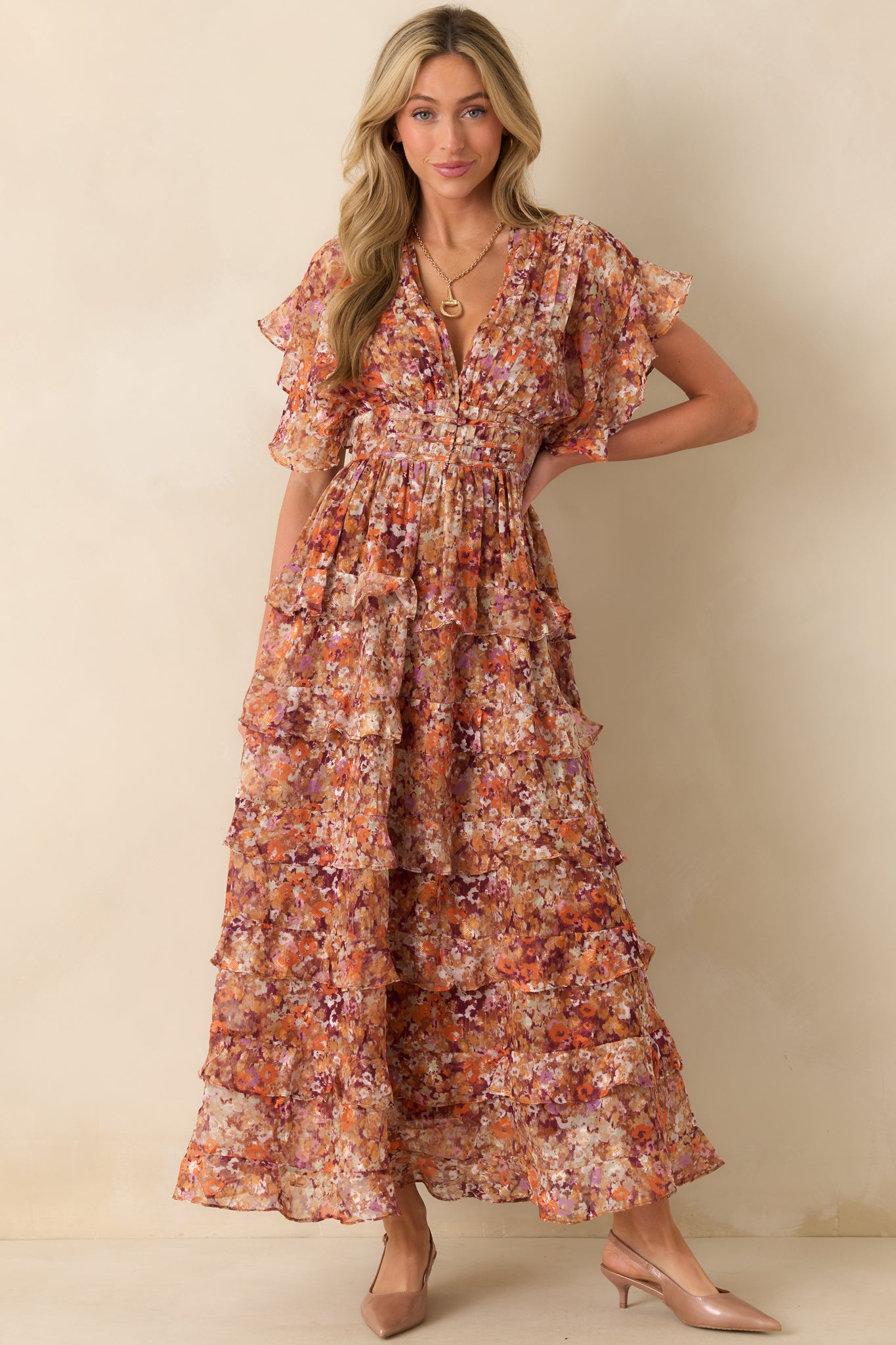 Front view of terracotta floral dress highlighting flutter sleeves and V-neckline.