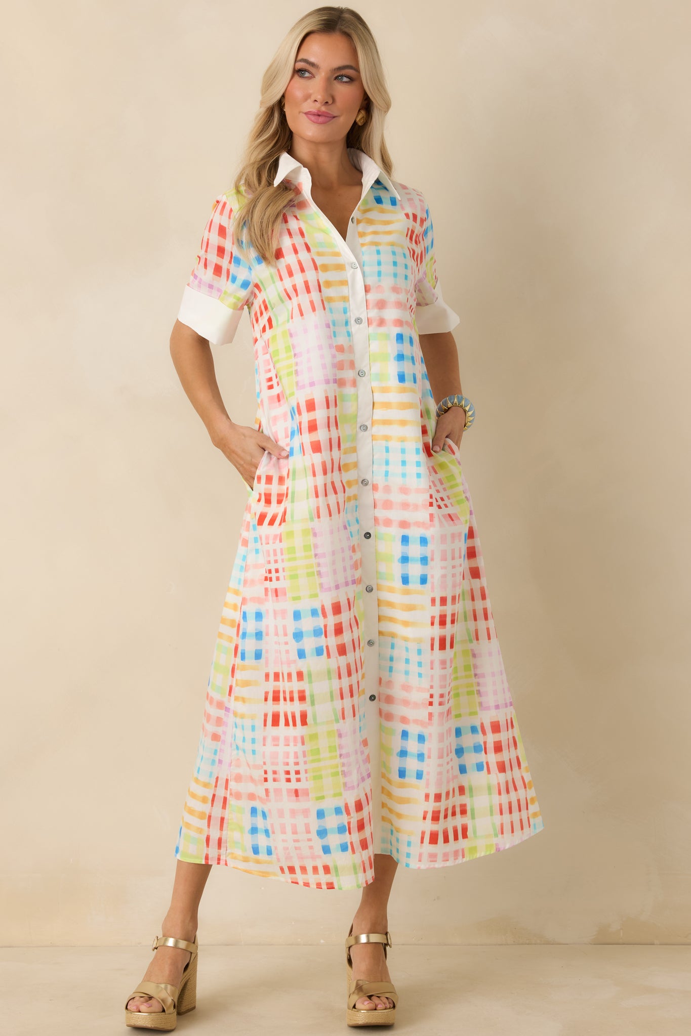 Front view emphasizing short cuffed sleeves, collared neckline, and all-over multicolor check pattern.