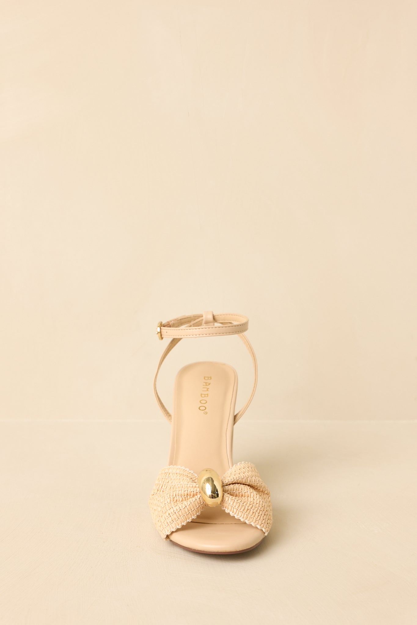 Front view of the woven sandals showing the bow-shaped strap, open toe, and sturdy block heel.