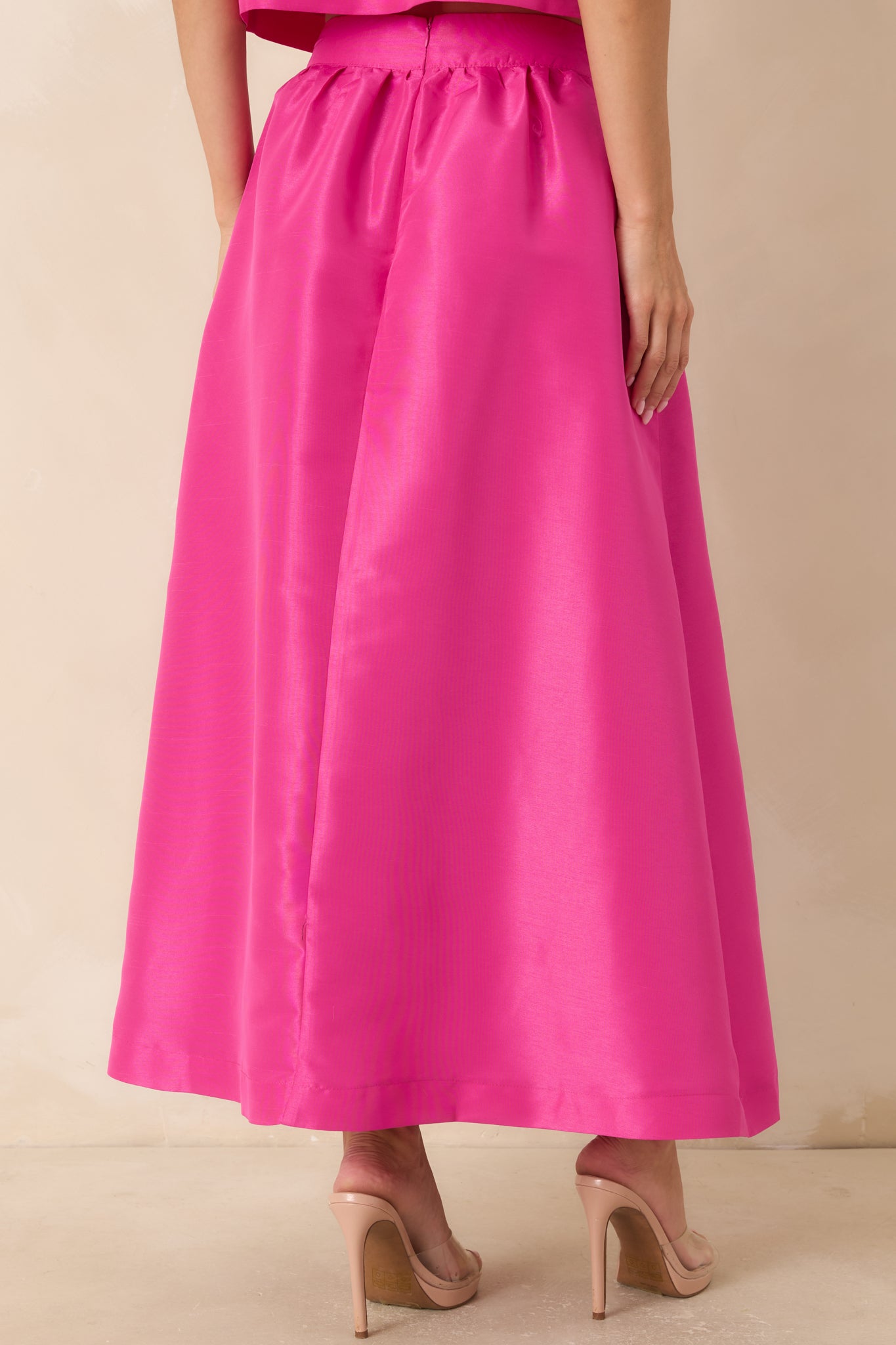 Back view of the fuchsia pink maxi skirt featuring the flowing silhouette and structured waistband.