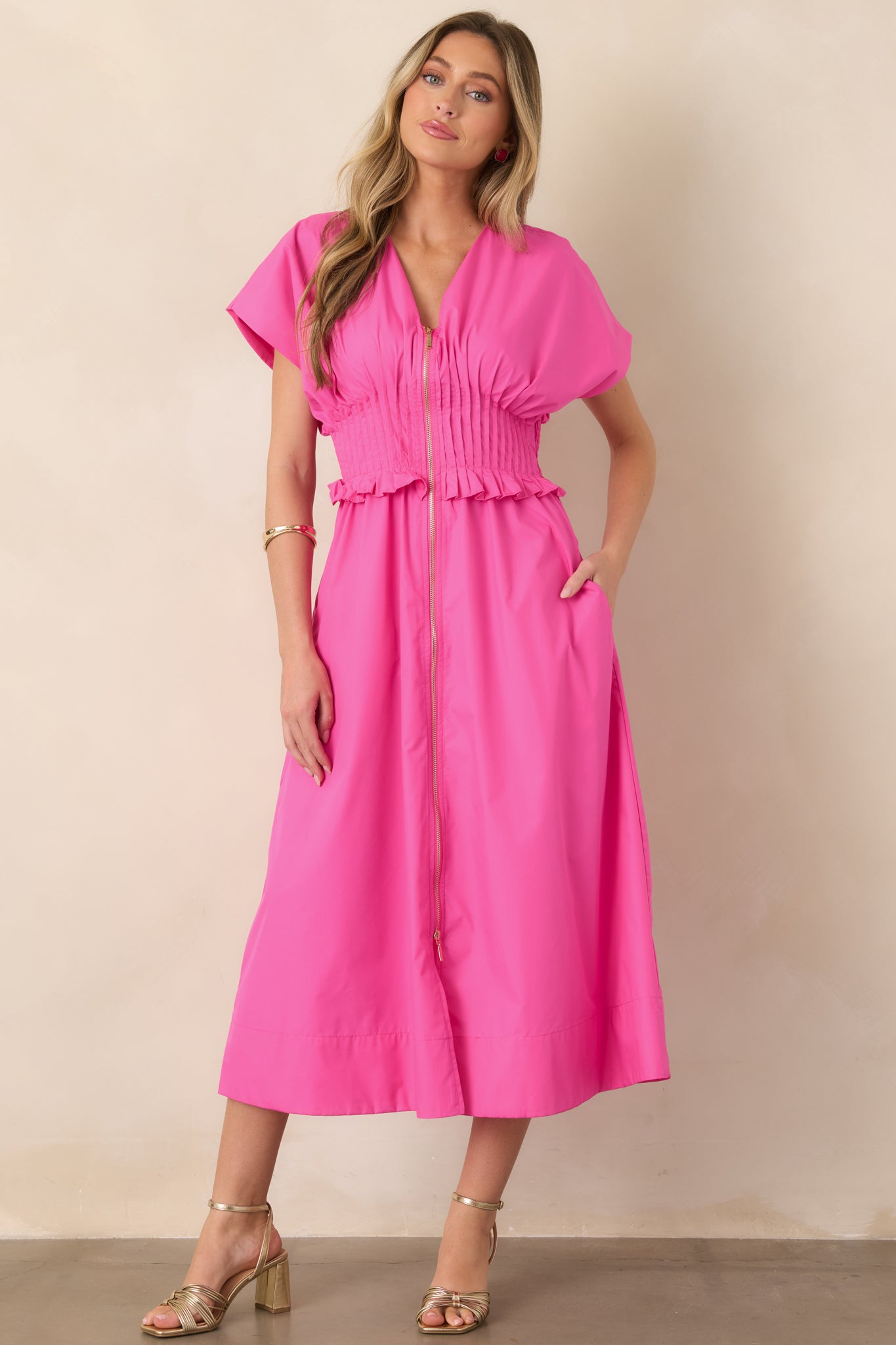 Fuchsia woven maxi dress with a V-neckline, short sleeves, front zip closure, wide smocked waistband, and relaxed A-line skirt.