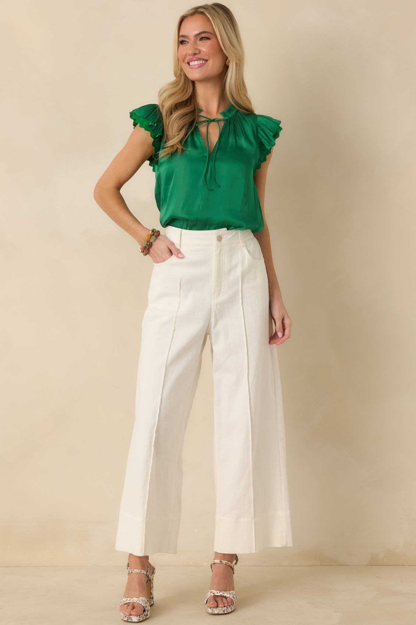 Front-facing full body image of the green woven blouse showcasing the flutter ruffle sleeves and lightweight silhouette.
