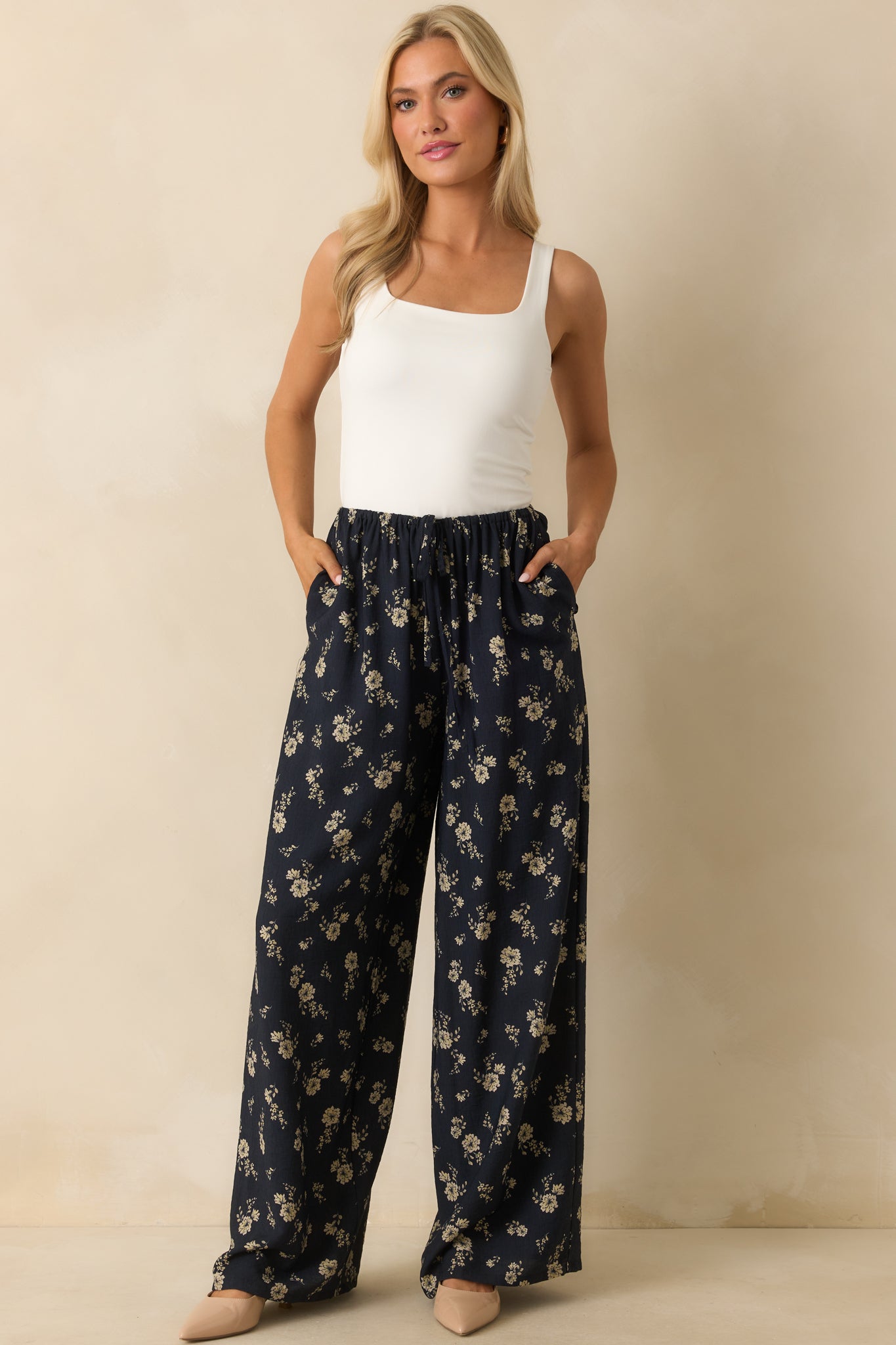 Full body shot of the pants, highlighting the ivory floral pattern and relaxed wide-leg design.