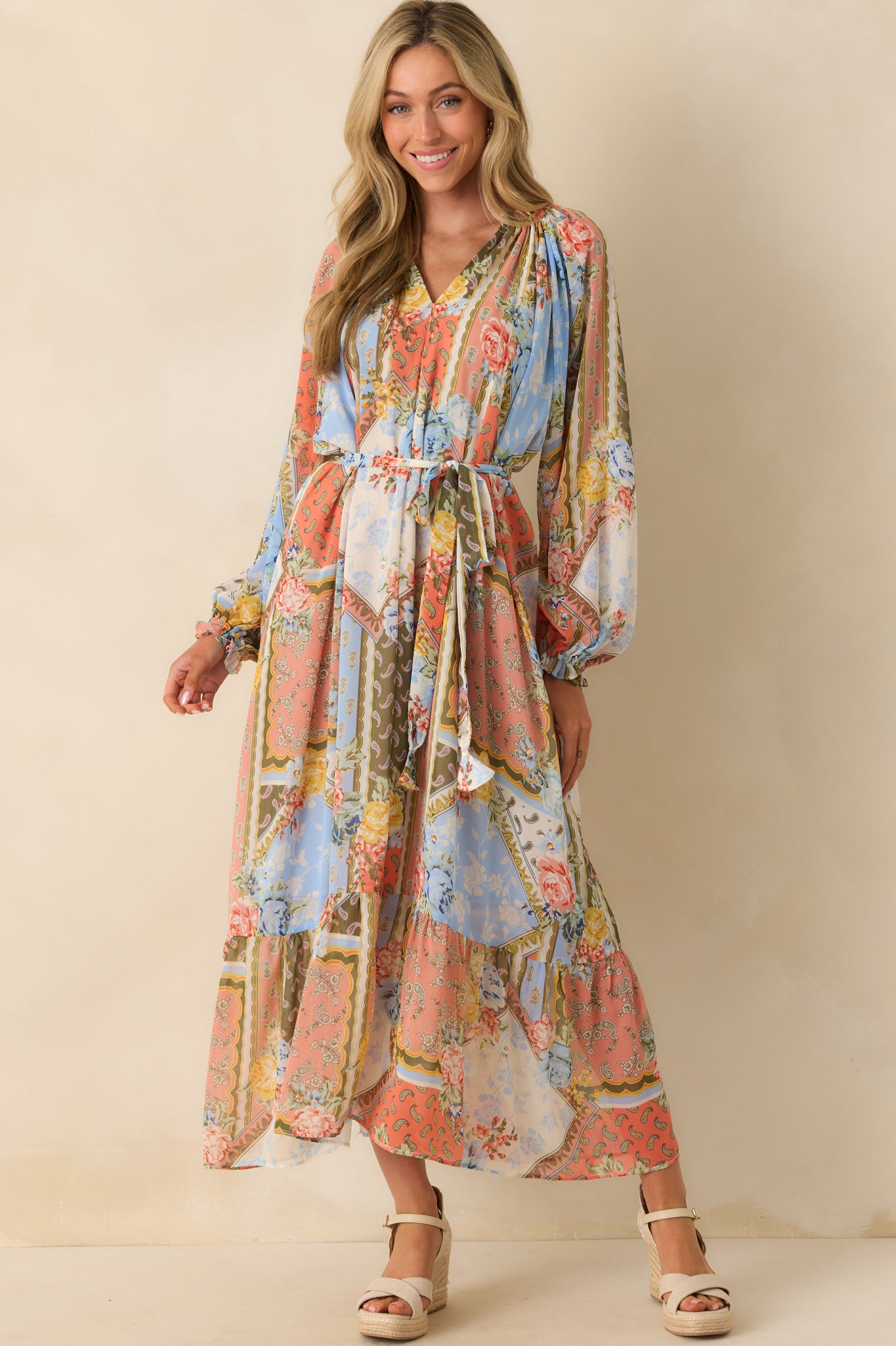 Full body shot emphasizing the V-neckline and tiered ruffled bottom hem of the dress.