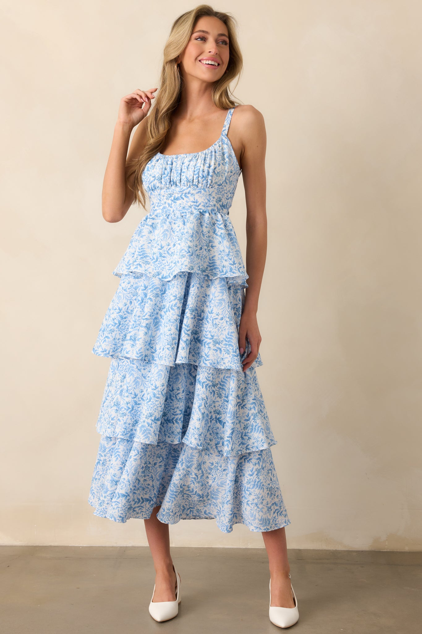 A full-body shot of the blue floral maxi dress, featuring the tiered skirt and textured fabric. The elastic scoop neckline and adjustable straps provide a flattering fit.