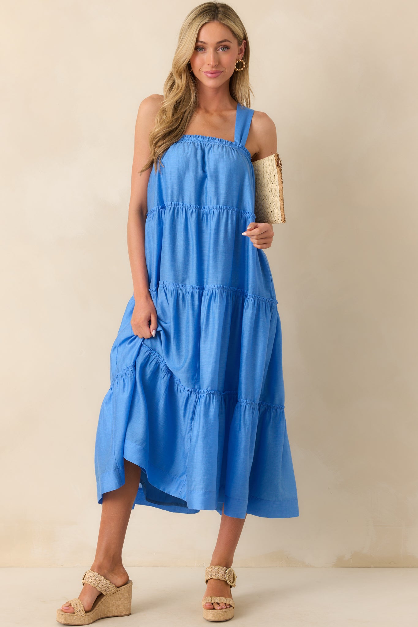 Full body view emphasizing the wide straps, layered ruffle detailing, and overall loose fit of the blue midi dress.