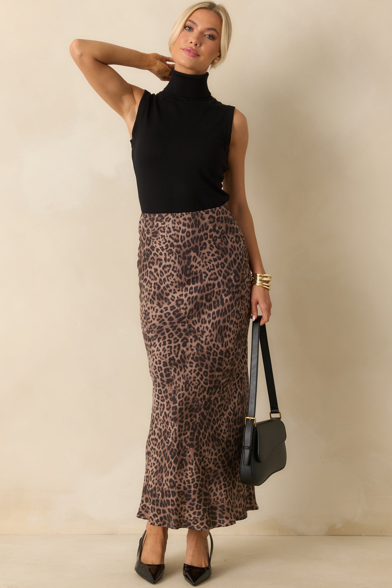 A full front view of the black sleeveless sweater featuring a ribbed roll turtleneck.