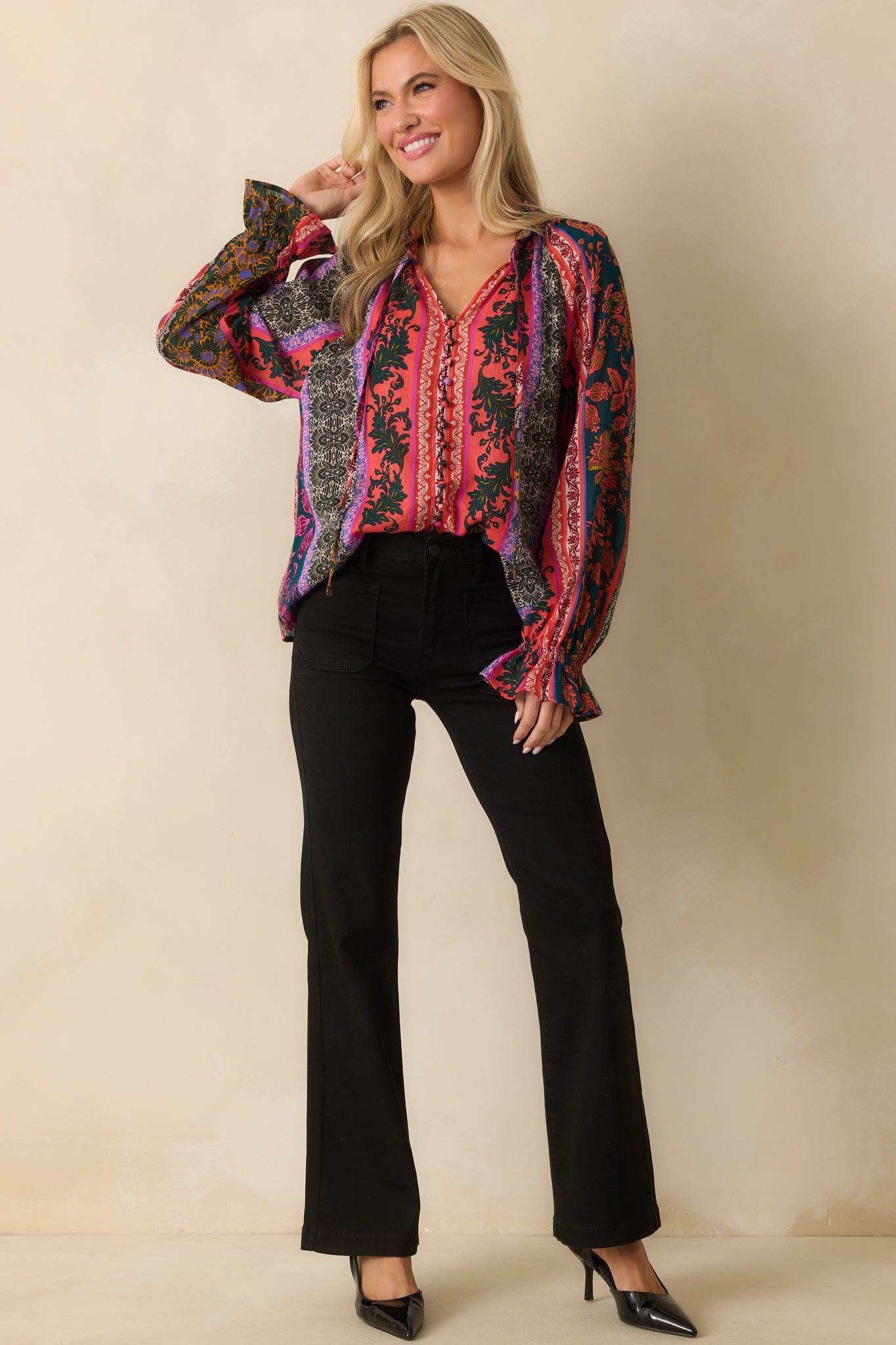 A full front view of the dark teal blouse featuring a multicolor patchwork print and notched V-neckline.
